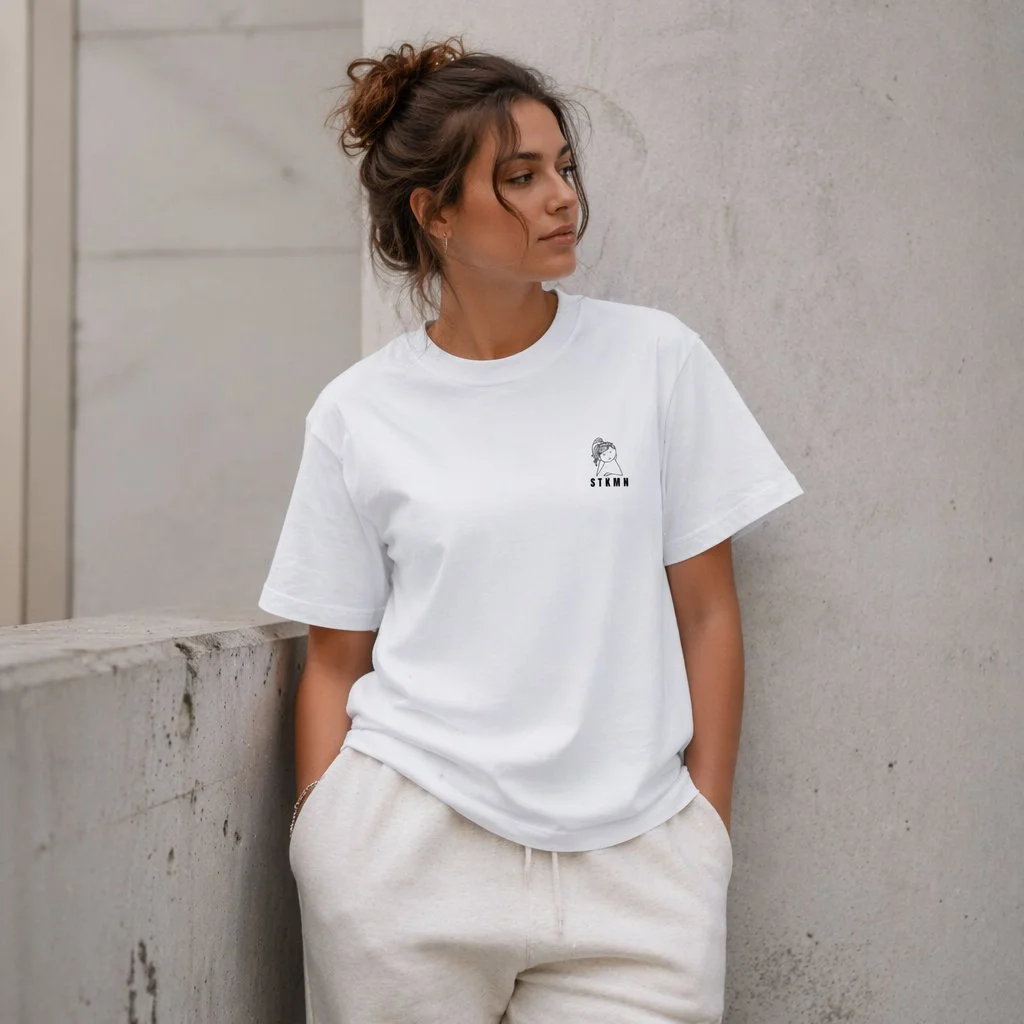 Model wearing the STKMN Essential Tee with girl graphic in white.