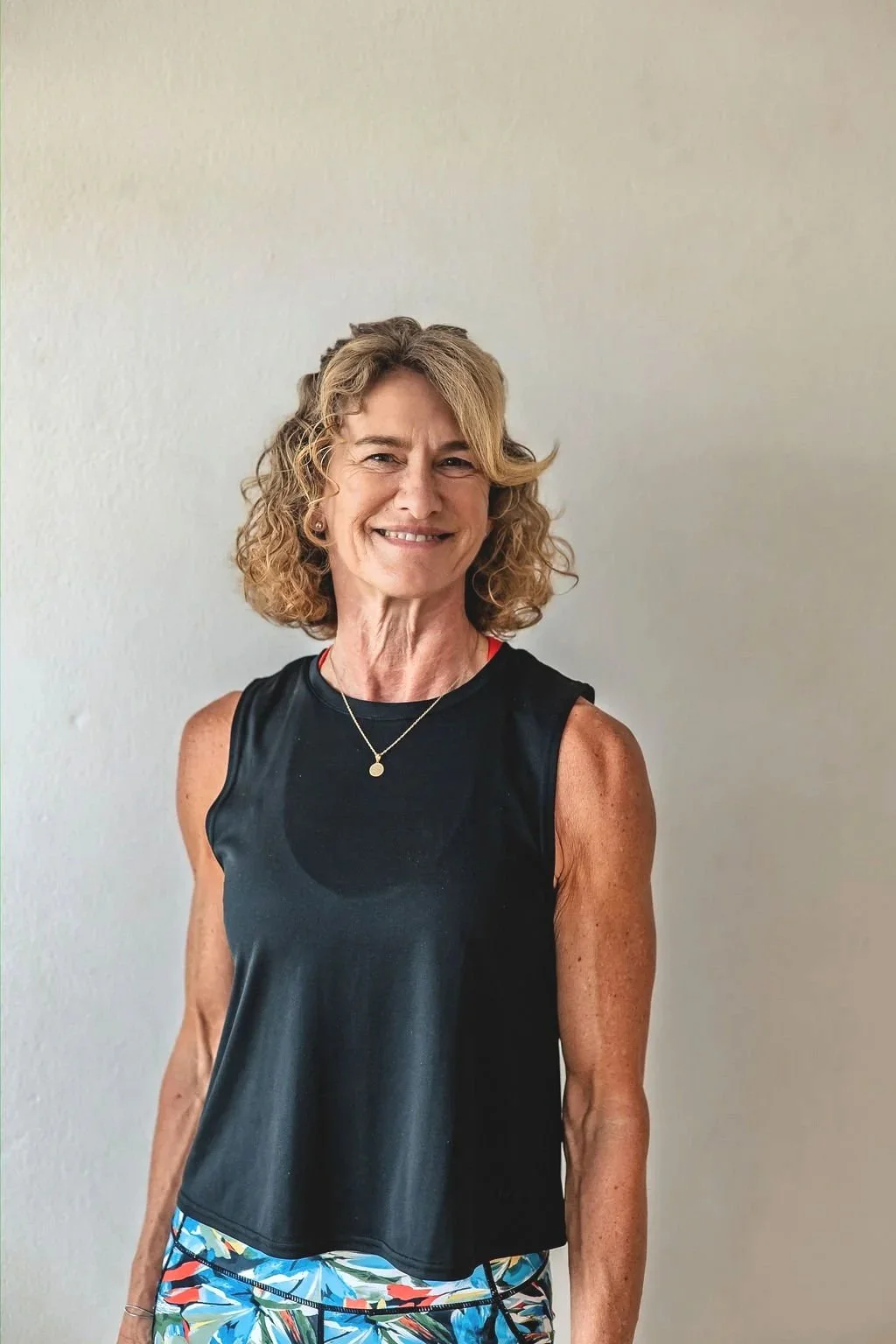 Julie smiling to the camera in sports clothes.