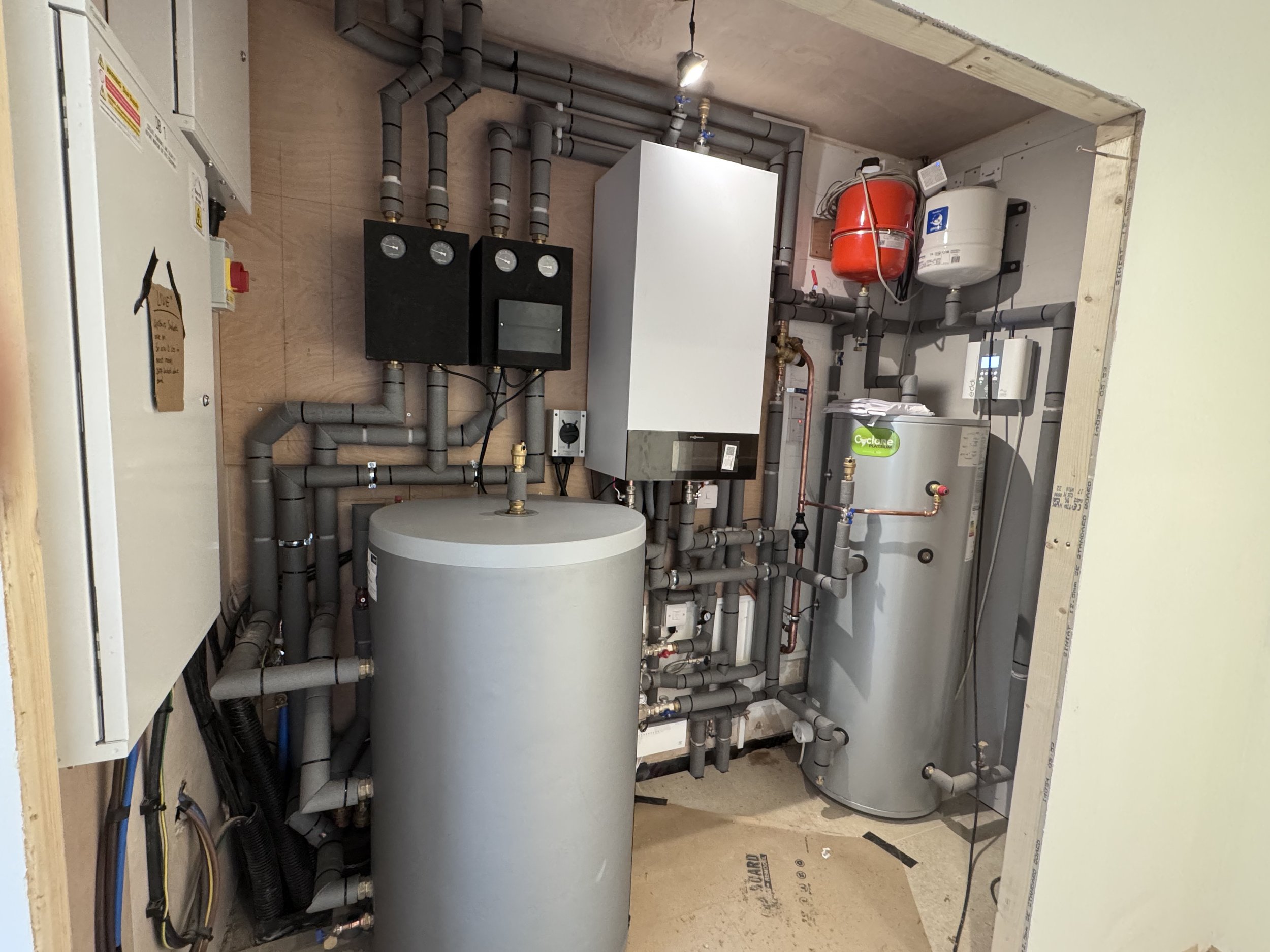 a viessmann vitocal 150 -a plant room, hot water cylinder, buffer, expansion vessels, and viessmann divicons, providing un mixed and mixed circuits.
