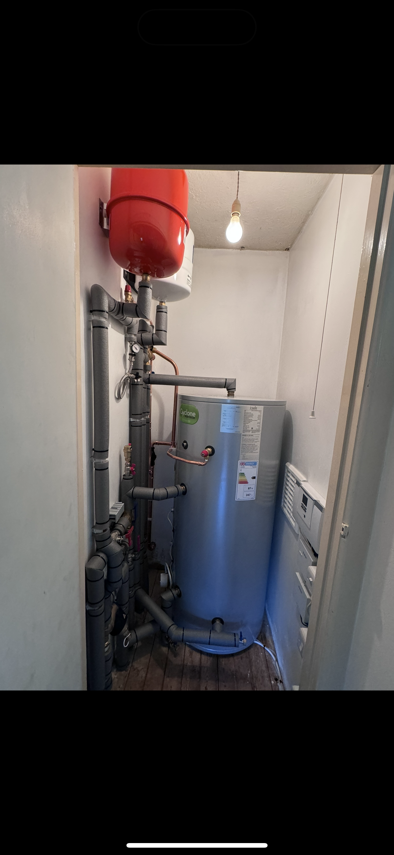 An airing cupboard with a hot water cylinder paired with a renewable heating system