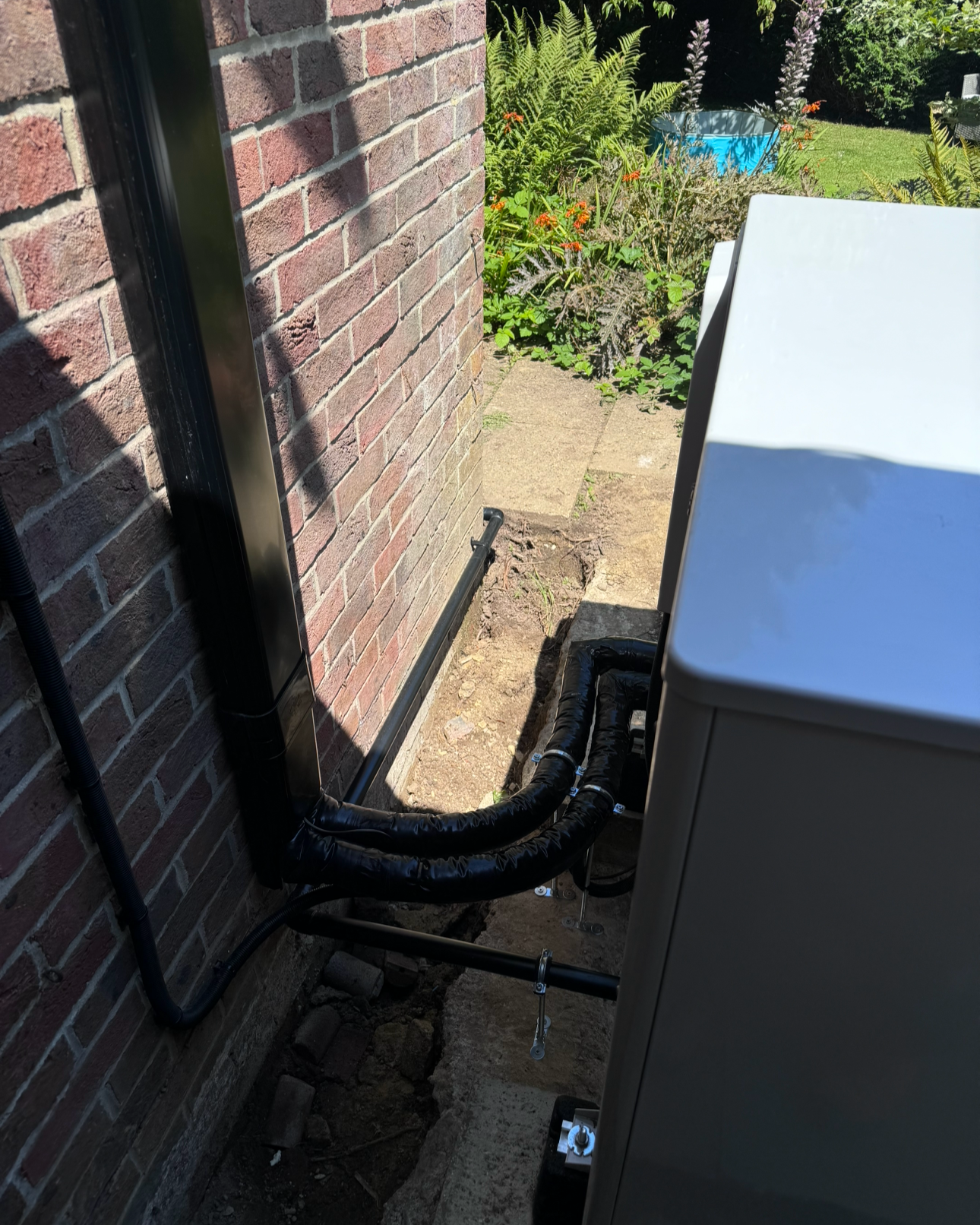 The back of a vaillant arotherm plus, condensate managed to manufacturer instructions, well insulated and properly supported pipework