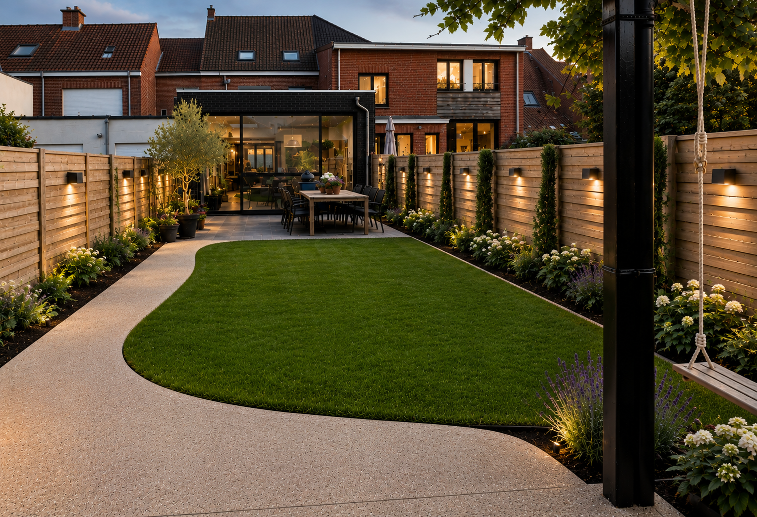 A modern backyard with a curved light-colored concrete path, lush green grass, and flower beds with white and purple flowers. There are wooden fences on both sides, some with outdoor lights. In the background, there is a house with a glass patio area