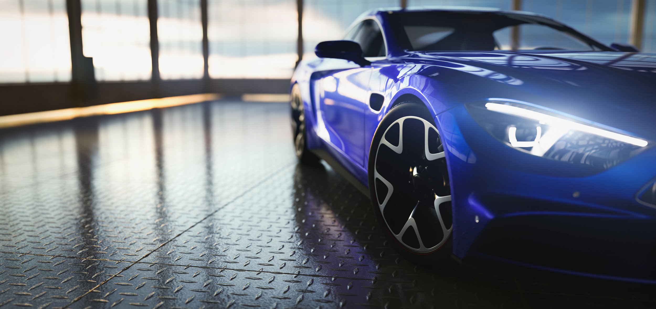 Close-up of a shiny blue sports car with black and white wheels, parked indoors near a glass window, reflecting light and creating a sleek appearance.