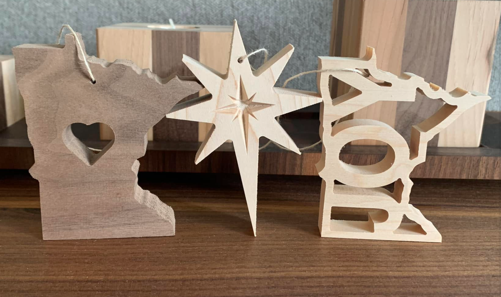Wooden decorations spelling out 'LOVE' with a star, placed on a wooden surface.