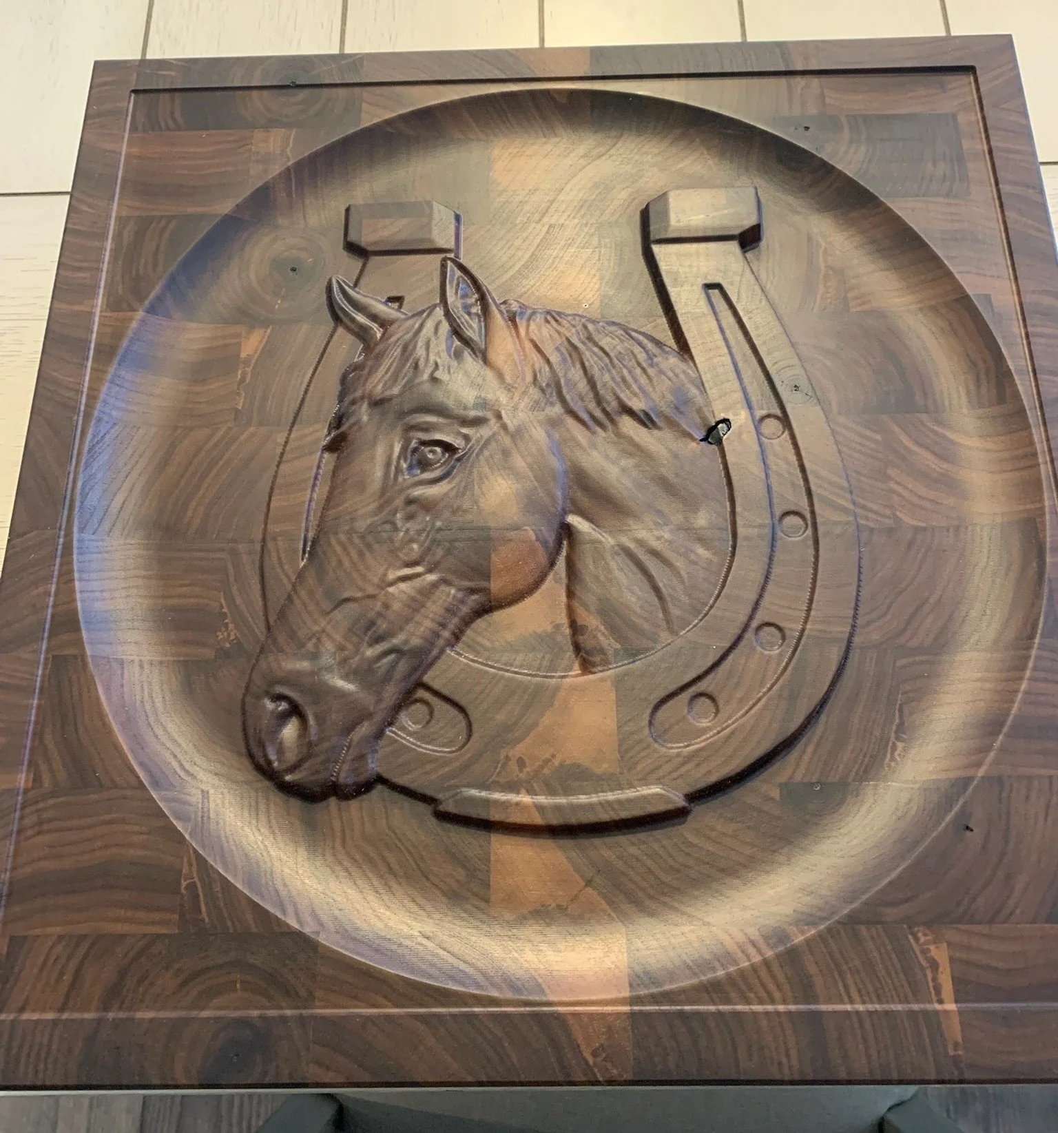 Wooden wall clock with a carved horse head and a metallic horseshoe design.