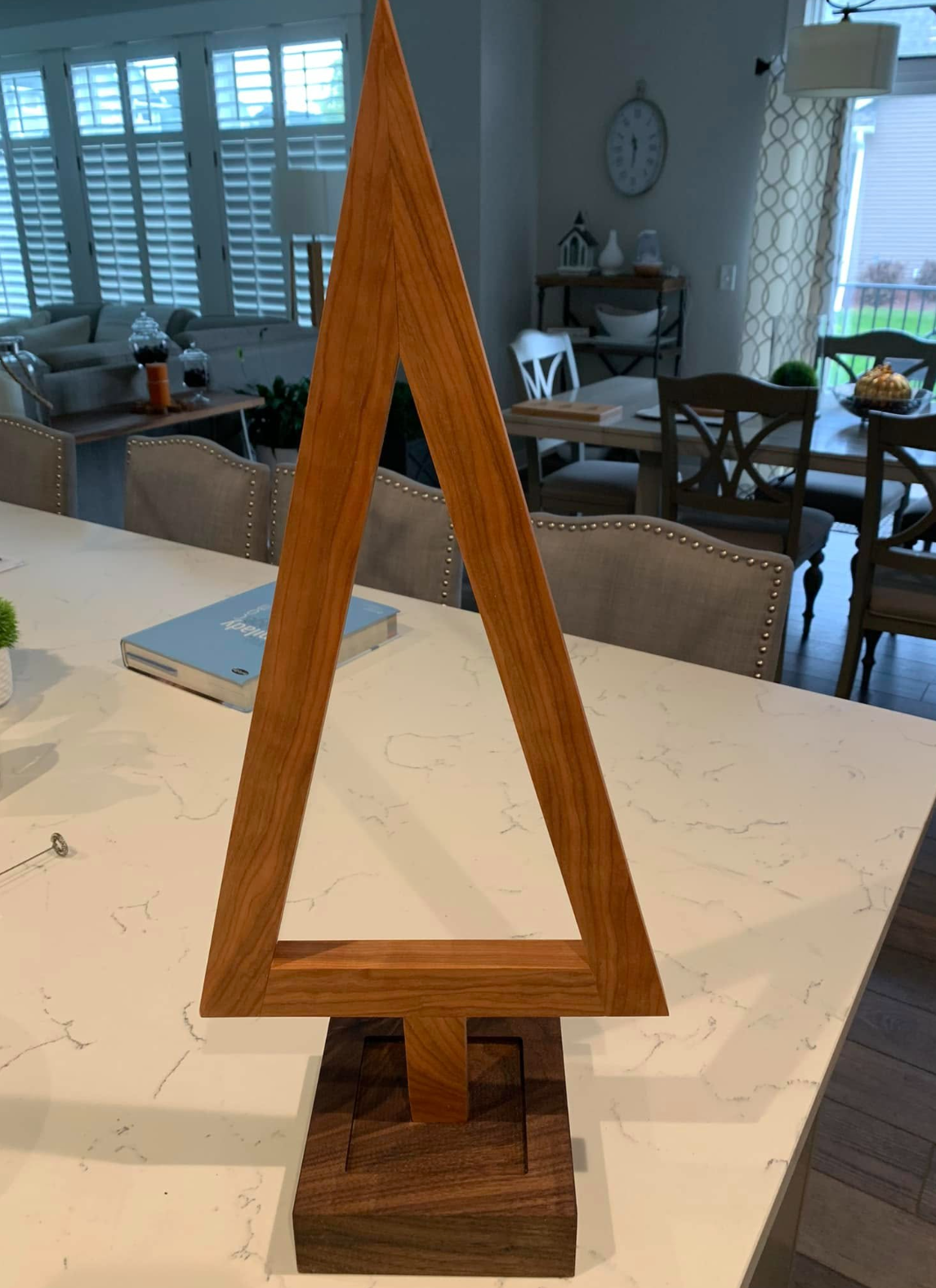 wooden triangular geometric decor on a white marble table in a modern dining room.