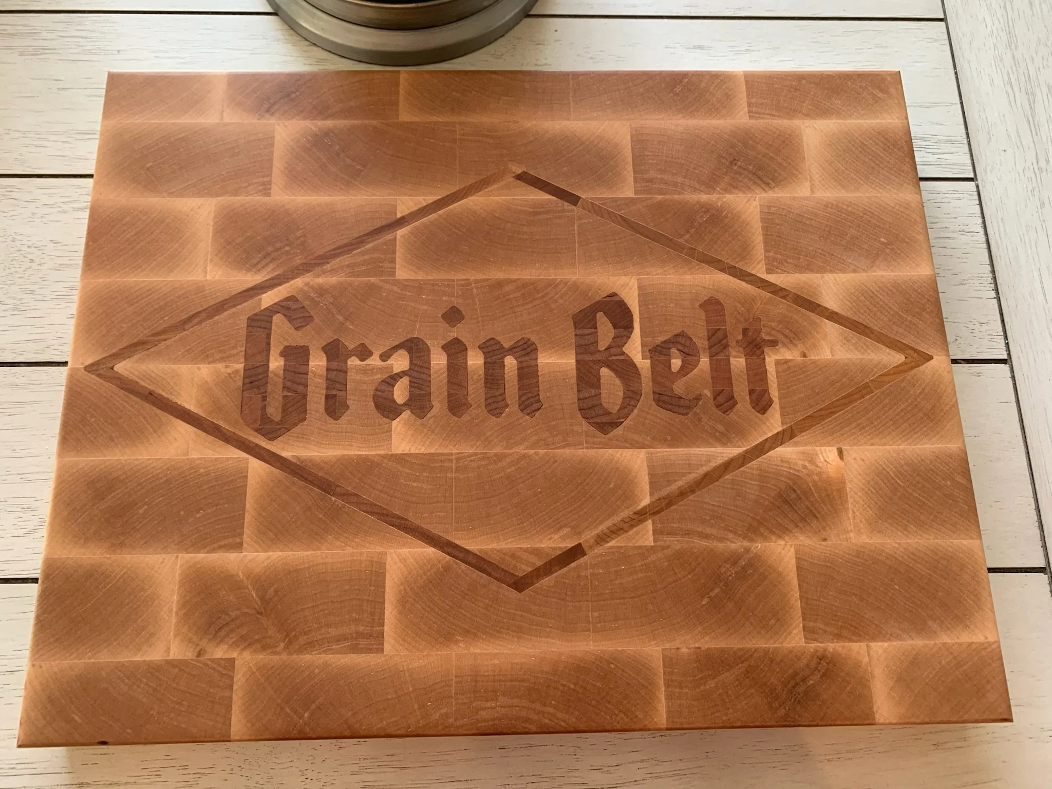 A wooden block with engraved text 'Train Bet' on a light-colored wooden surface.