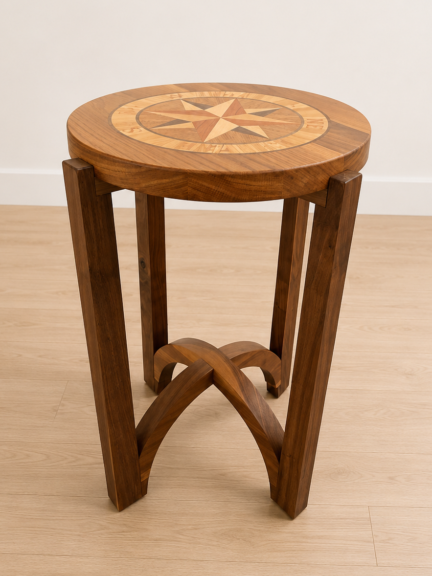 Wooden round side table with a star compass design on top, supported by four slanted legs that are connected at the bottom with curved crossbars.