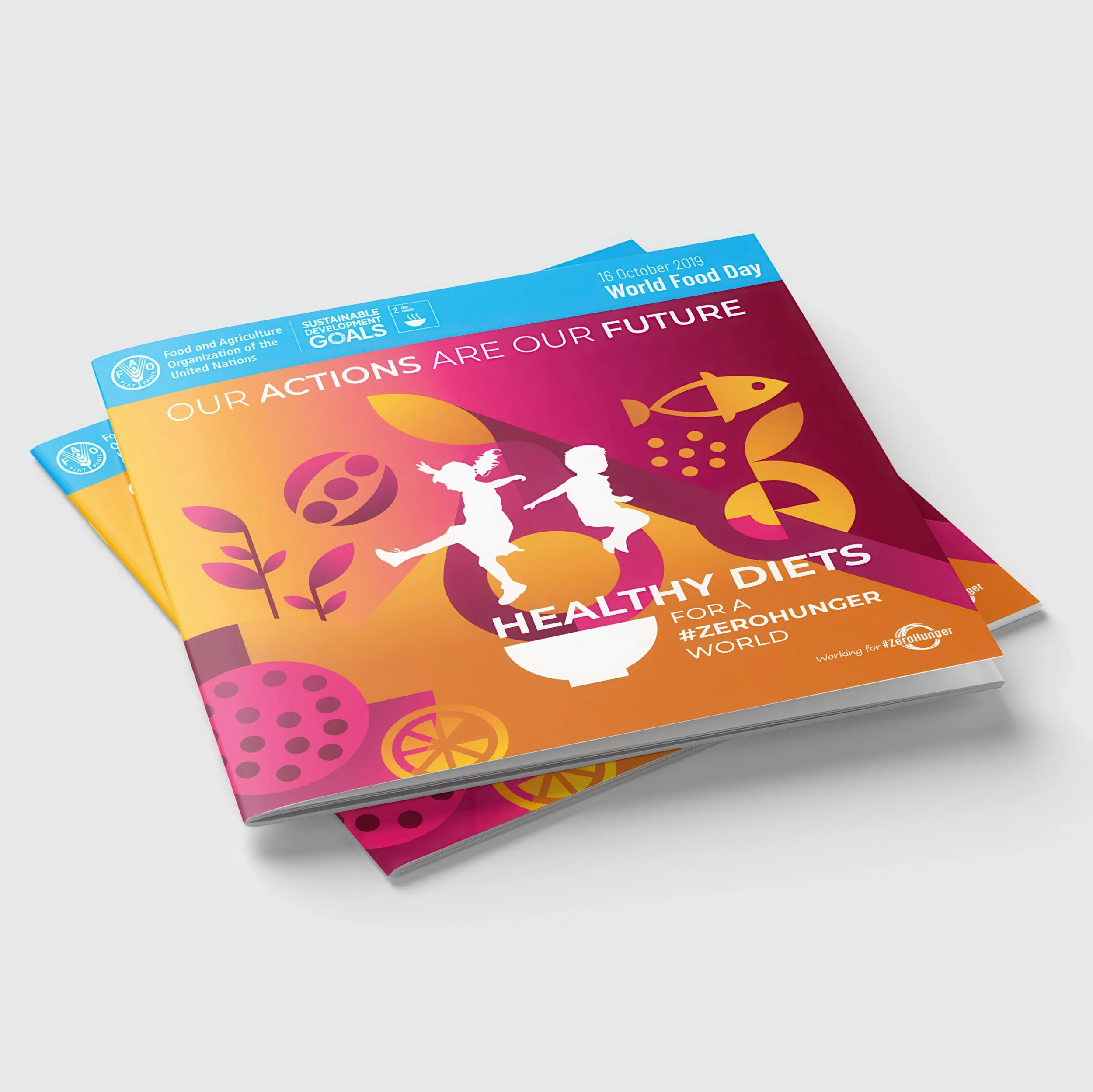 Colorful brochure with text about World Food Day, healthy diets, and sustainable development goals, featuring illustrations of children and fruits, laid on a white surface.