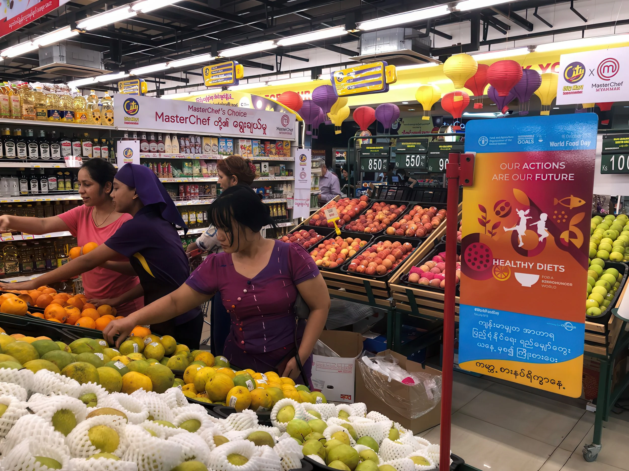 People shopping for fruits at a supermarket, with shelves of peaches and other produce, and colorful lanterns hanging from the ceiling.
