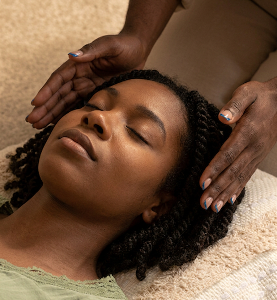 Woman receiving a head massage while lying down with eyes closed, person massaging her scalp with hands.