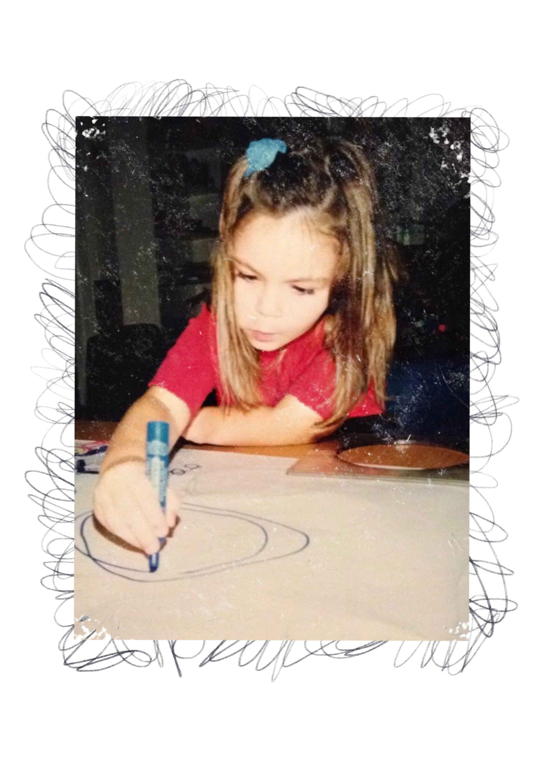 A young girl with light brown hair, wearing a red shirt and a blue hair scrunchie, drawing circles on a piece of paper with a blue marker.