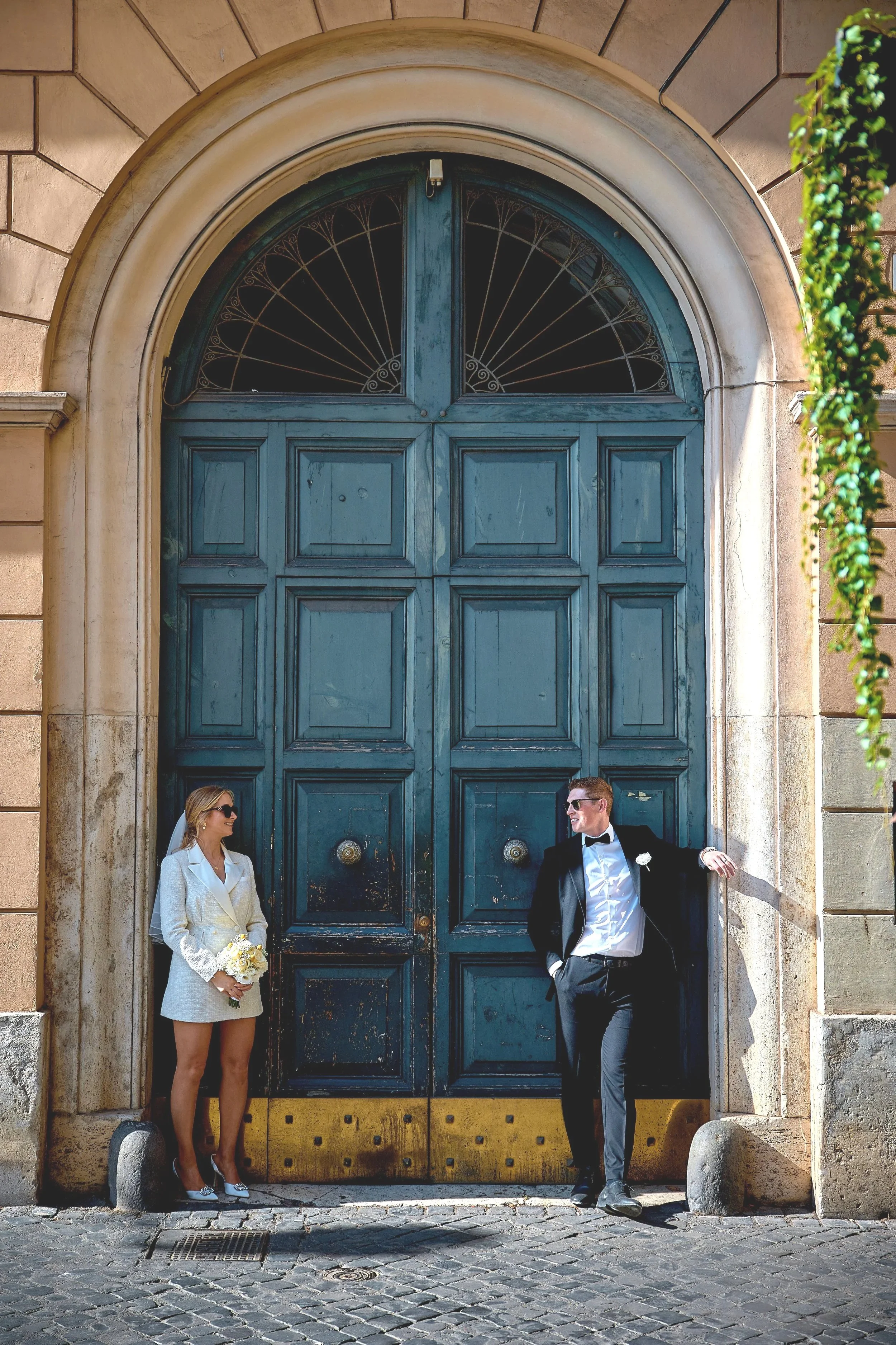 Couple by a blue historic Roman door at their elopement — Rome Luxury Elopements