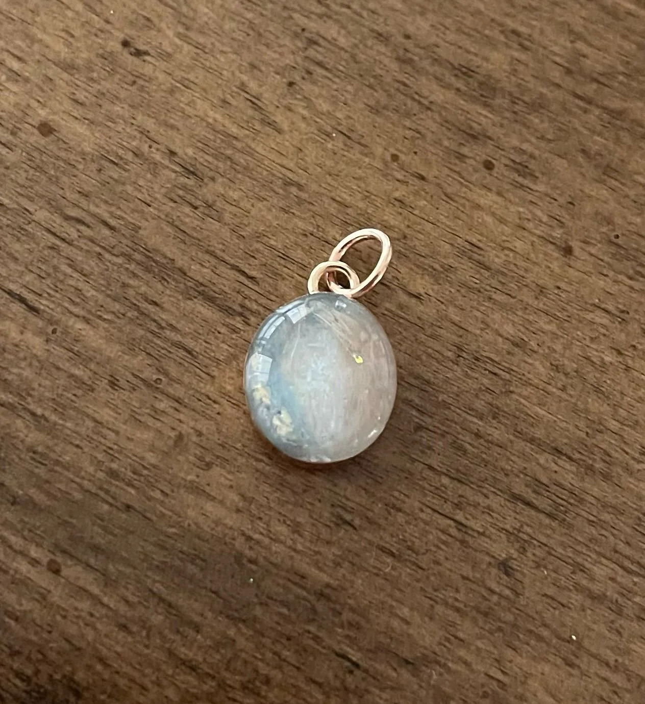 Necklace pendant for a sweet little girl who lost her bunny. Her bunny&rsquo;s name was moon and she likes the color blue. Placed the hair and the blue in a crescent moon shape and added opal dust along with texturizing more hair into the resin throu