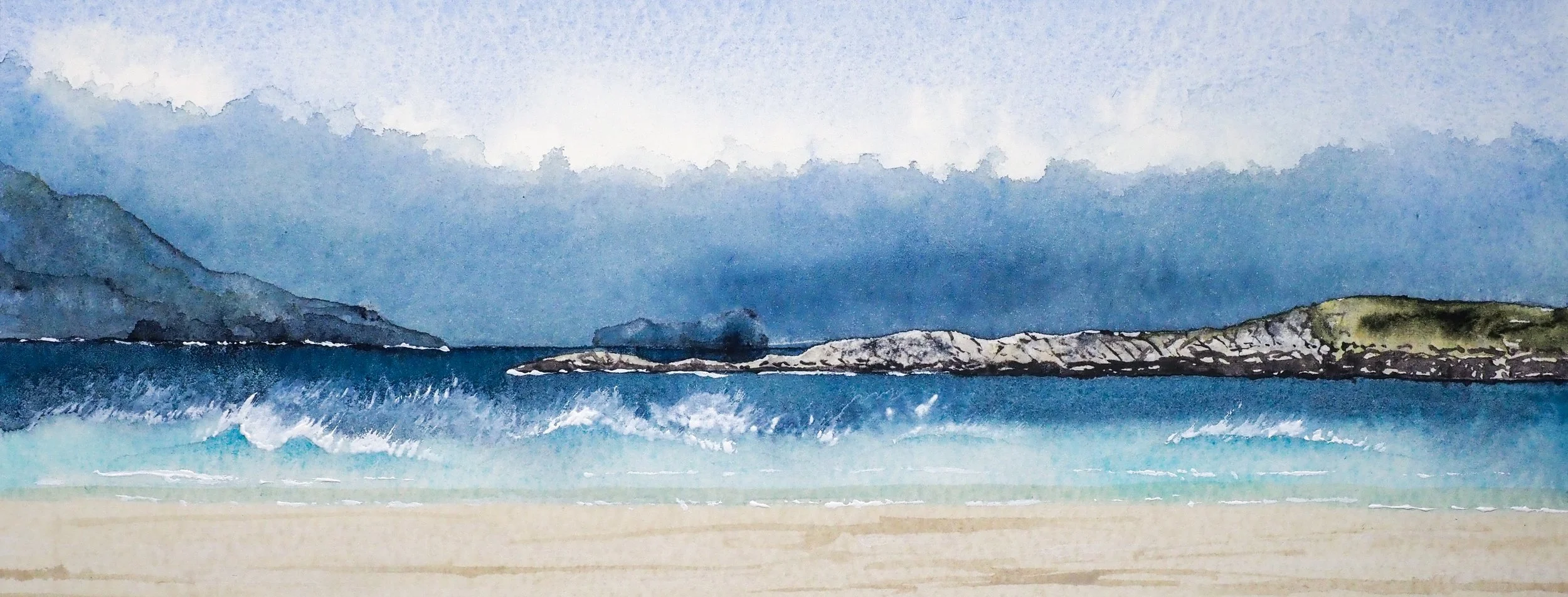 Waves breaking on a sunlit beach. Headland in the middle distance is in sun. A distant headland is enveloped in low fog