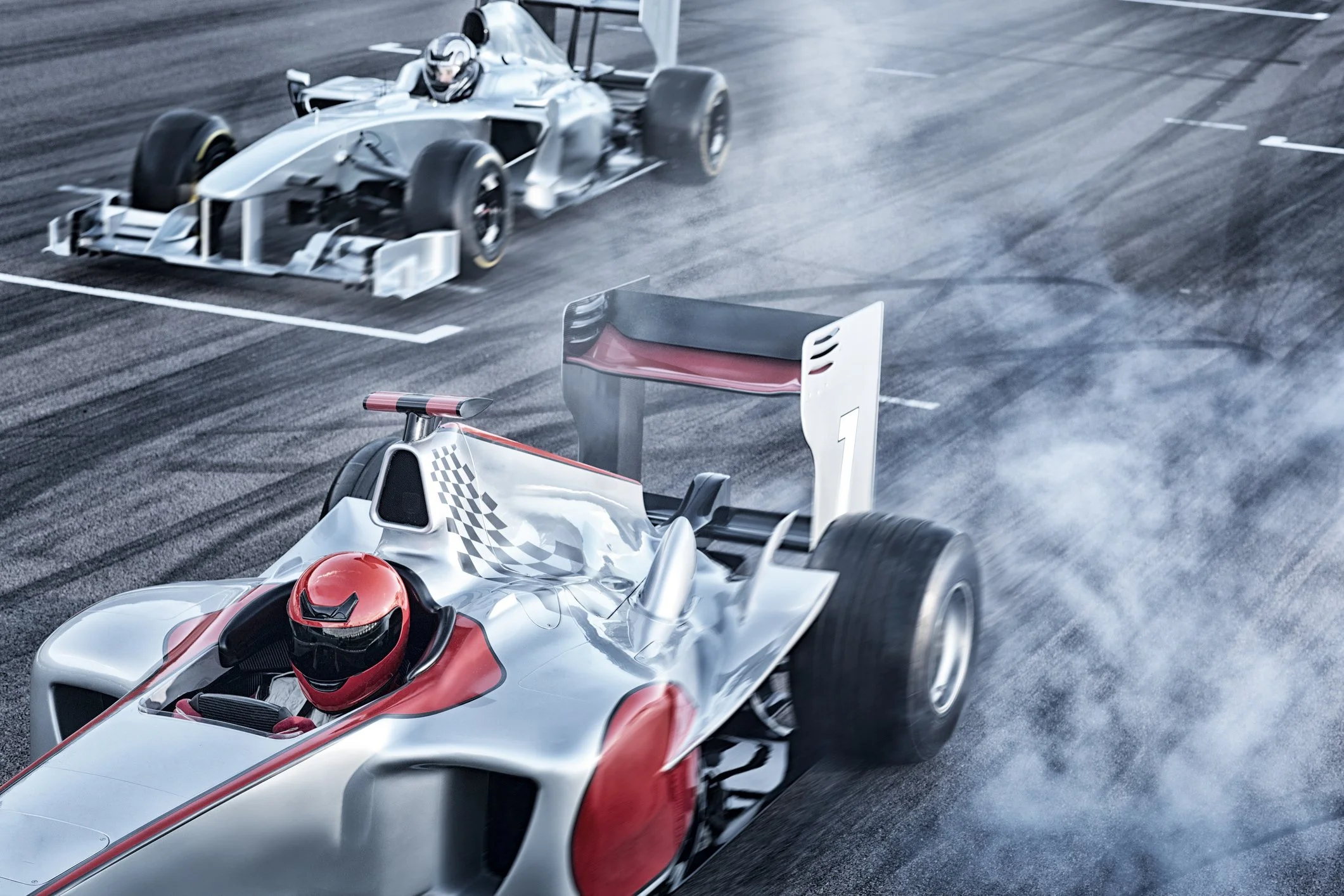 A race car driven by a person wearing a red helmet on a race track. The car is mostly white with red accents, and another similar car is visible in the background. Smoke or tire marks are on the track surface.