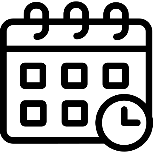 Silhouette of a person sitting at a desk working on a laptop with a coffee mug nearby.