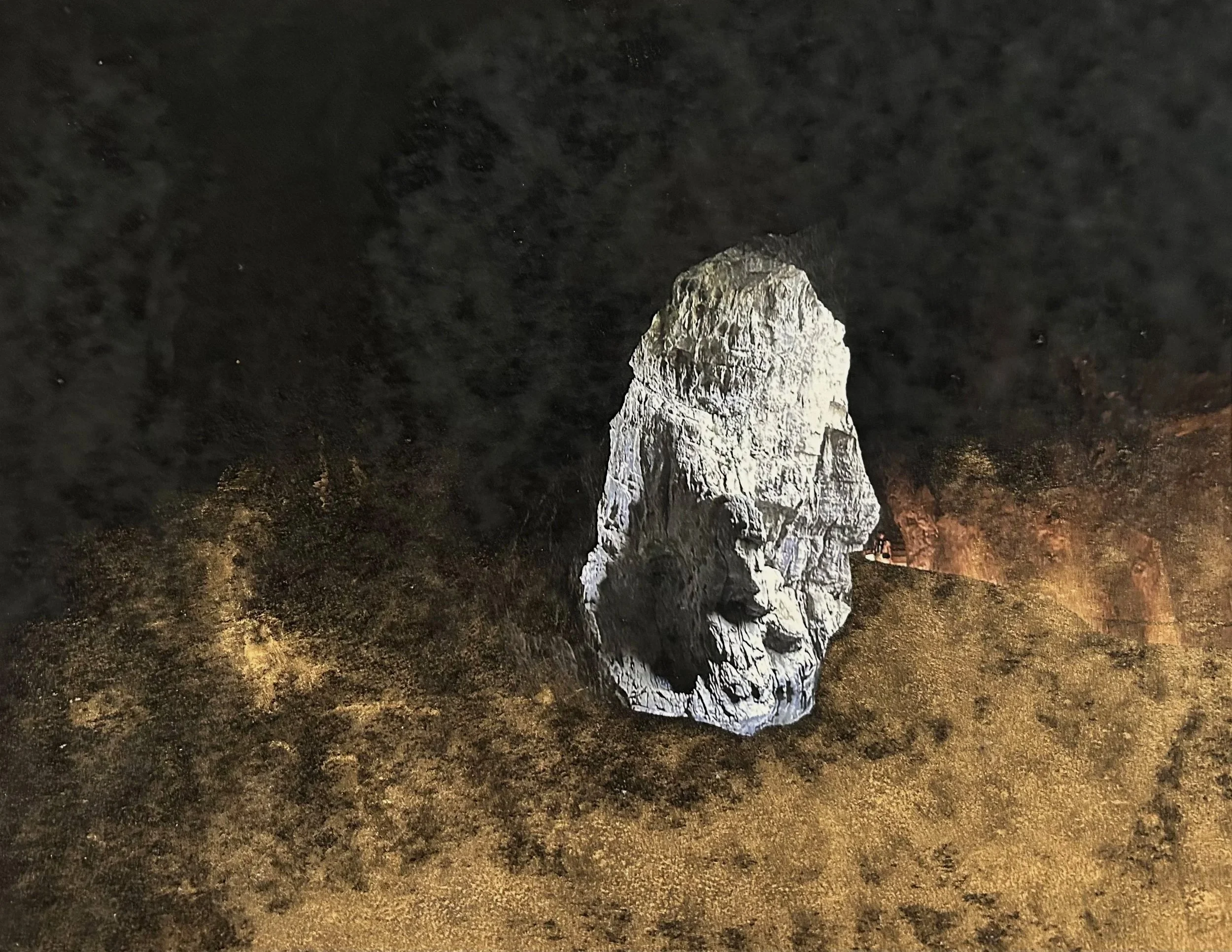 A large opening of a dark cave, illuminated from below.