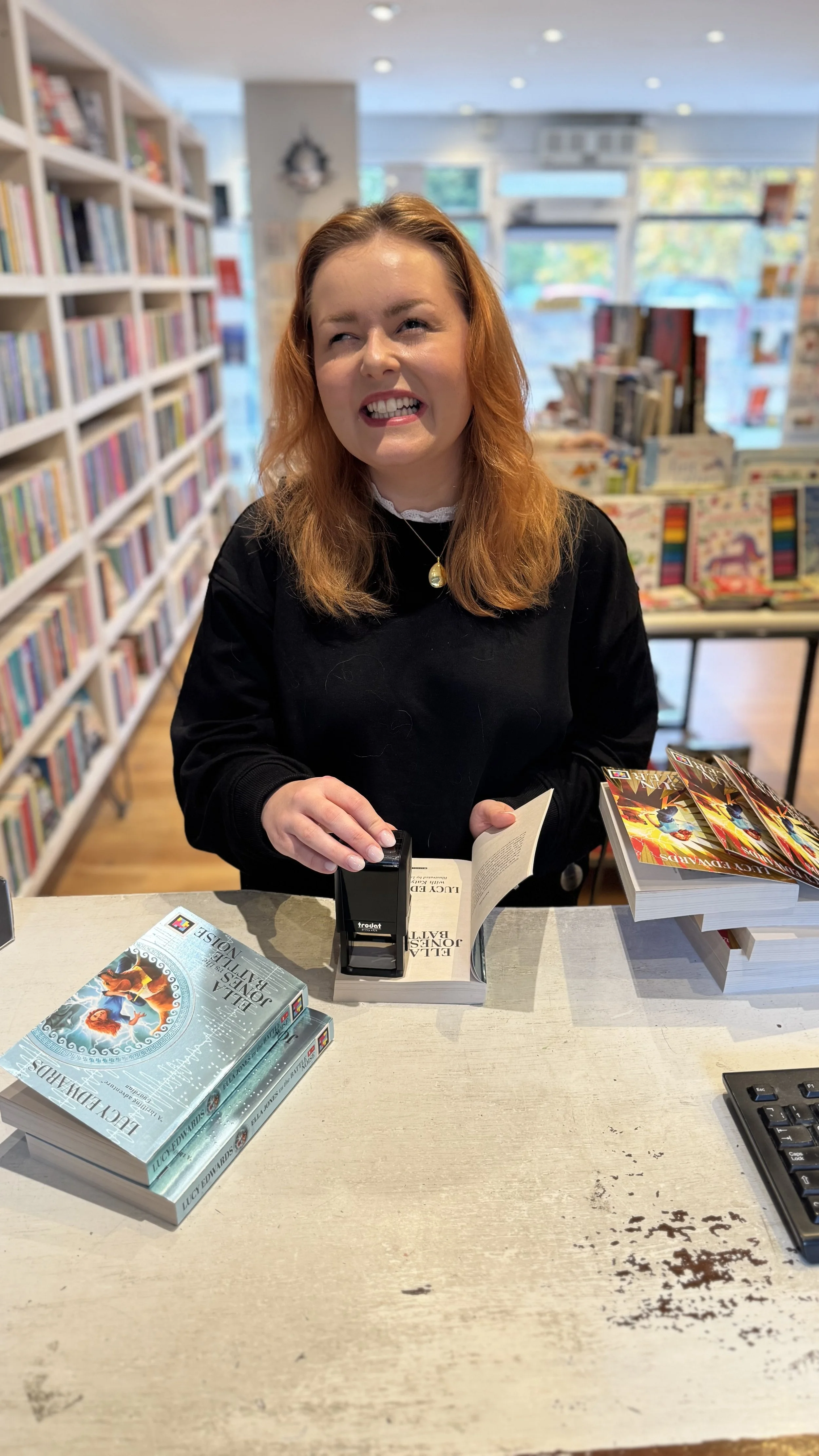 Lucy Edwards stamps copies of Ella Jones Vs The Battle Noise