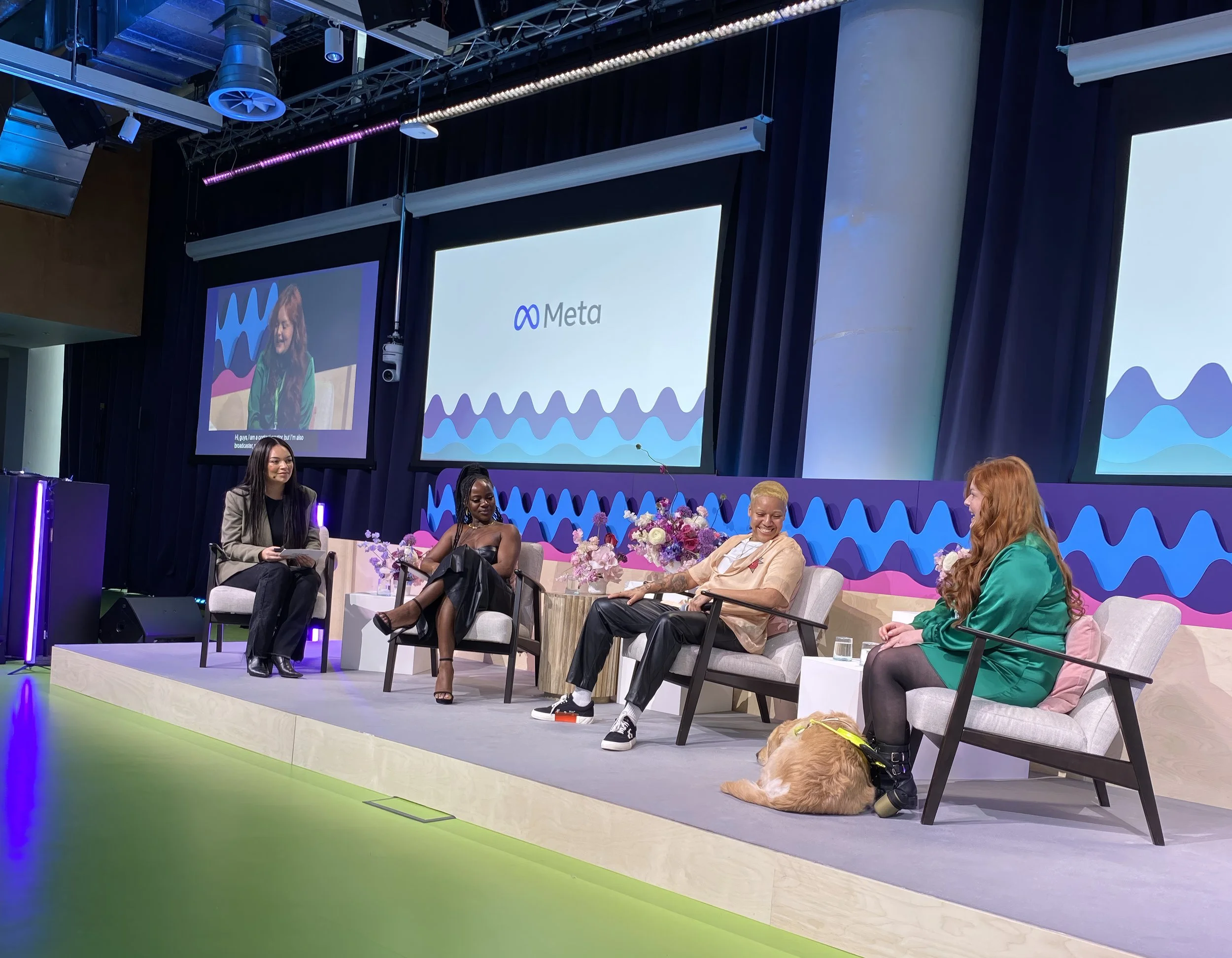 Lucy speaks on a panel with a huge Meta logo behind her. Miss Molly sits at her feed.
