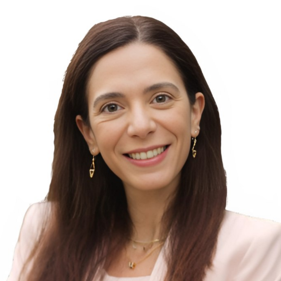 Professional headshot of a woman wearing a light pink suit, smiling against a white background.