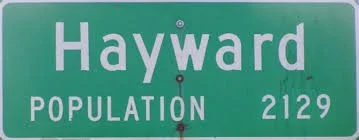 Green city street sign for Hayward with population 2,129