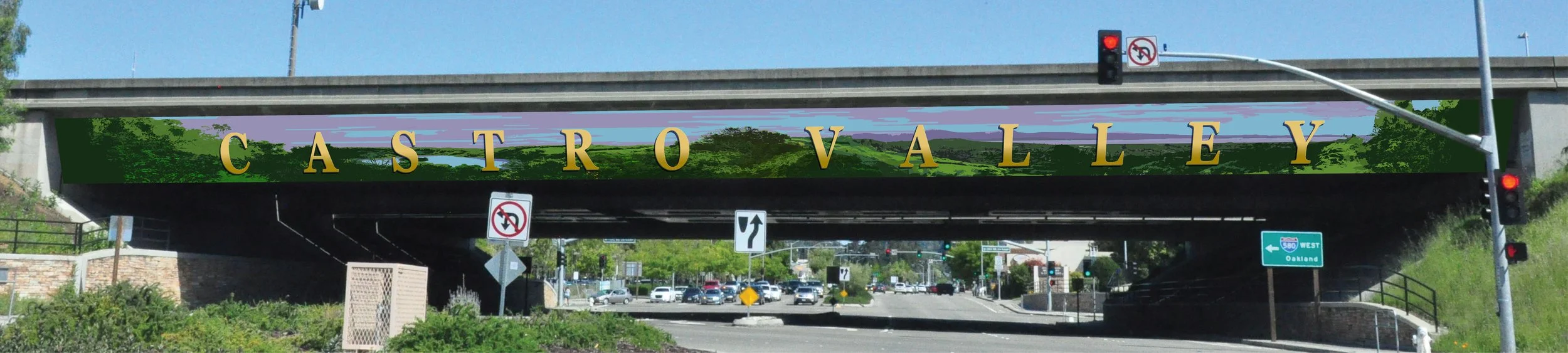 Bridge with a sign reading 'Castro Valley' over a highway with traffic signals and cars.