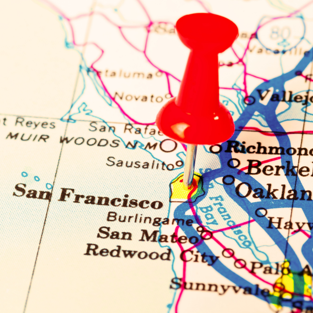 A close-up of a red push pin marking a location on a map of Northern California, near San Francisco.