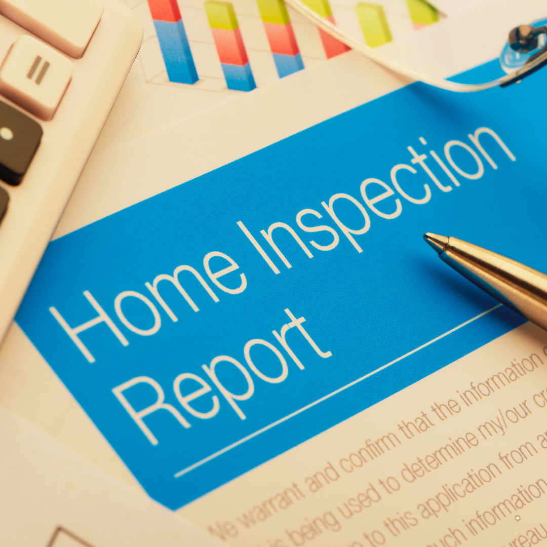 A blue homeowner inspection report cover with white text, a silver pen, a keyboard, and colorful charts or graphs on a white surface.