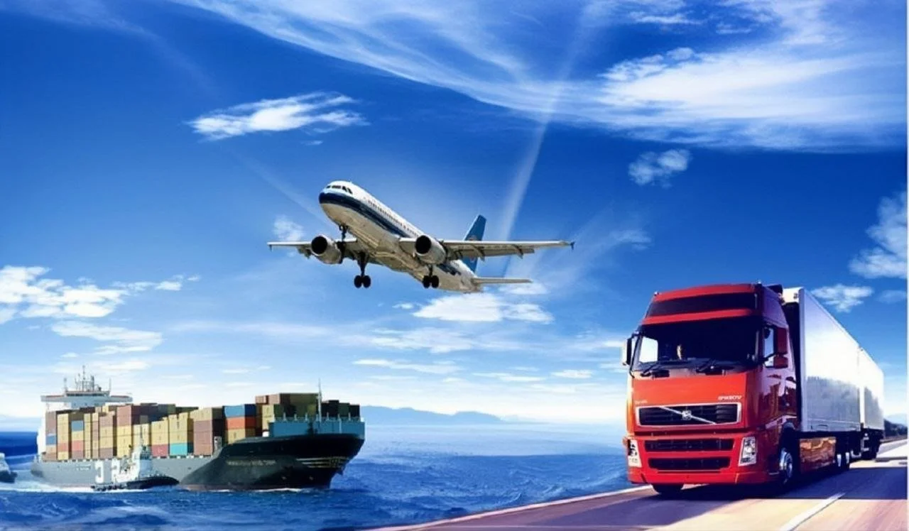 A cargo ship sailing on the ocean with a large container on deck, a red semi-truck driving on a road, and a commercial airplane flying in the sky above.