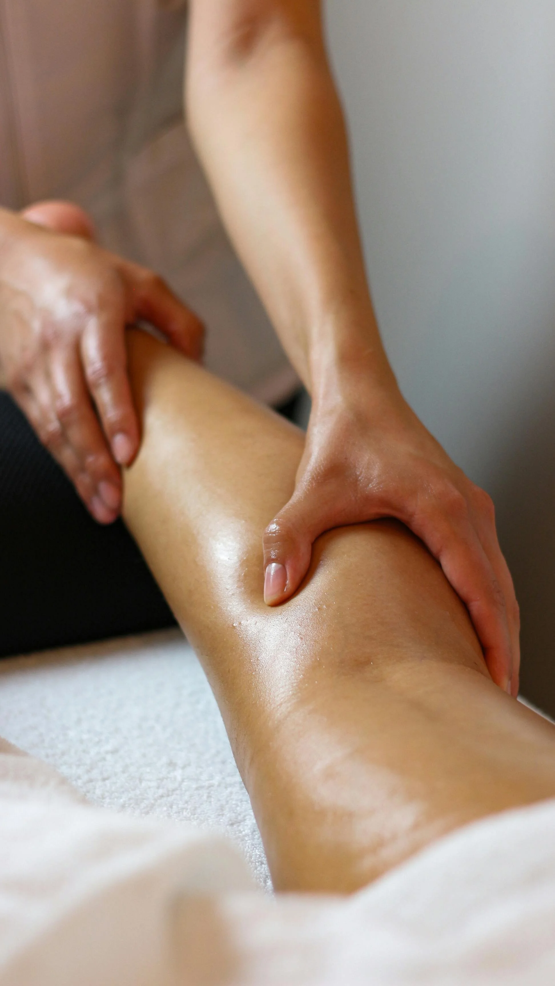 Une personne donne un massage à une autre personne, concentré sur la jambe.