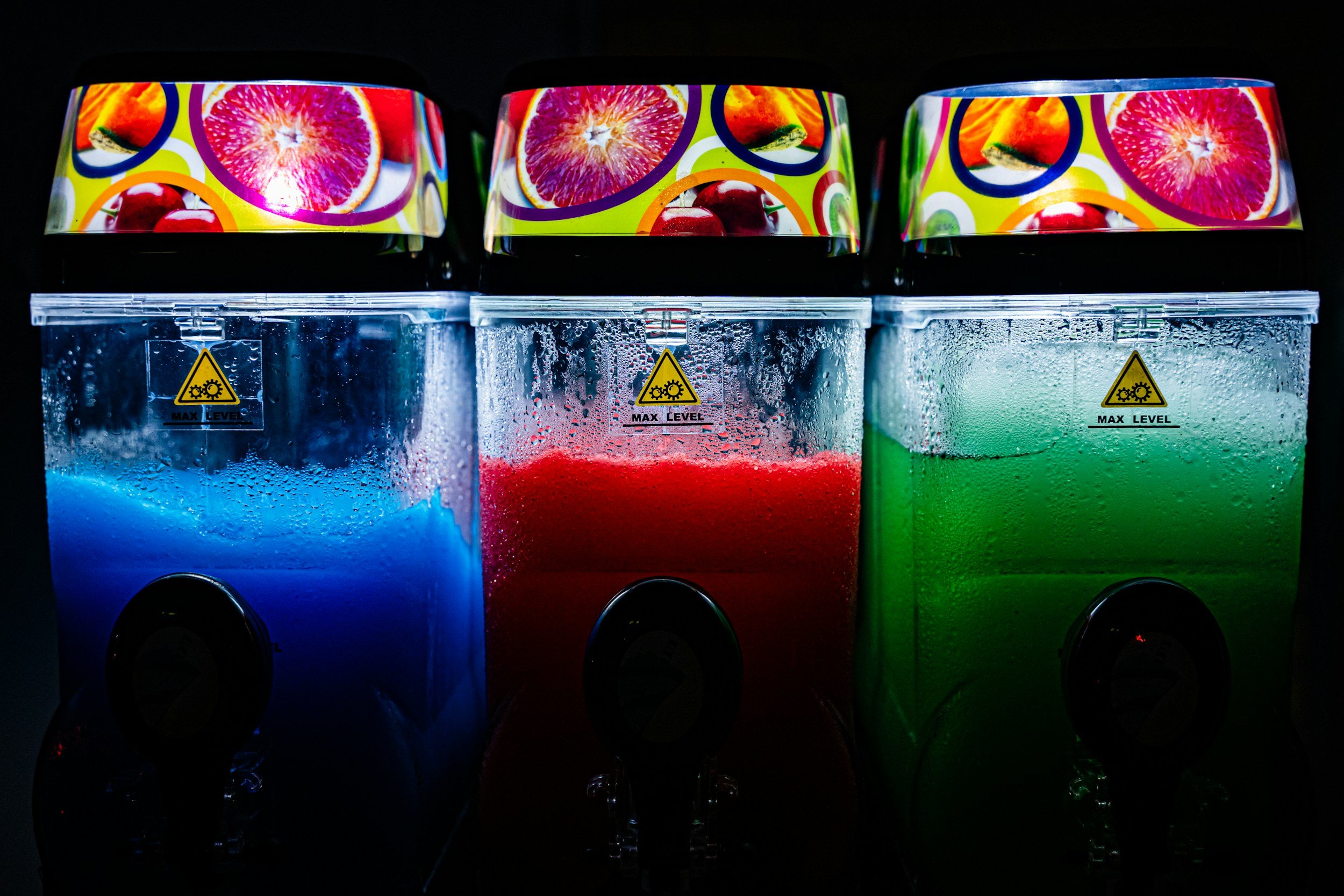 Trois distributeurs automatiques de slush bleu, rouge et vert