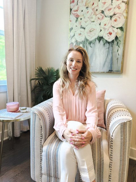 Hilla Flohr, LCSW-C, therapist sitting in a warm, welcoming space, smiling