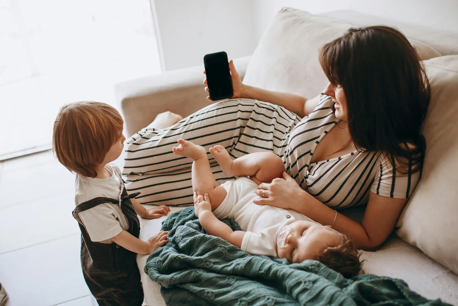 mother relaxing at home with her children receiving virtual postpartum support in san diego