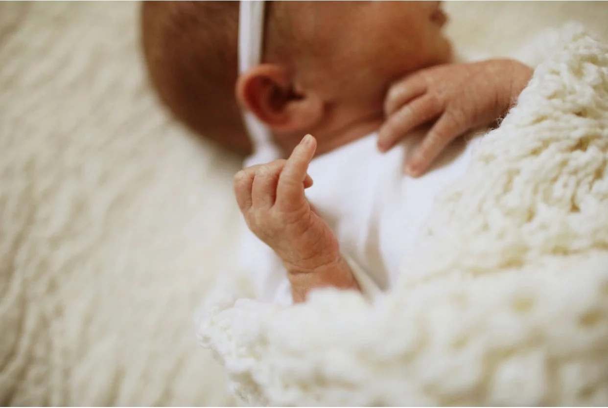 newborn baby sleeping on white blanket