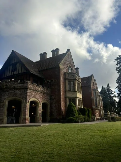 Large historic brick mansion with arched windows and a well-maintained front lawn.