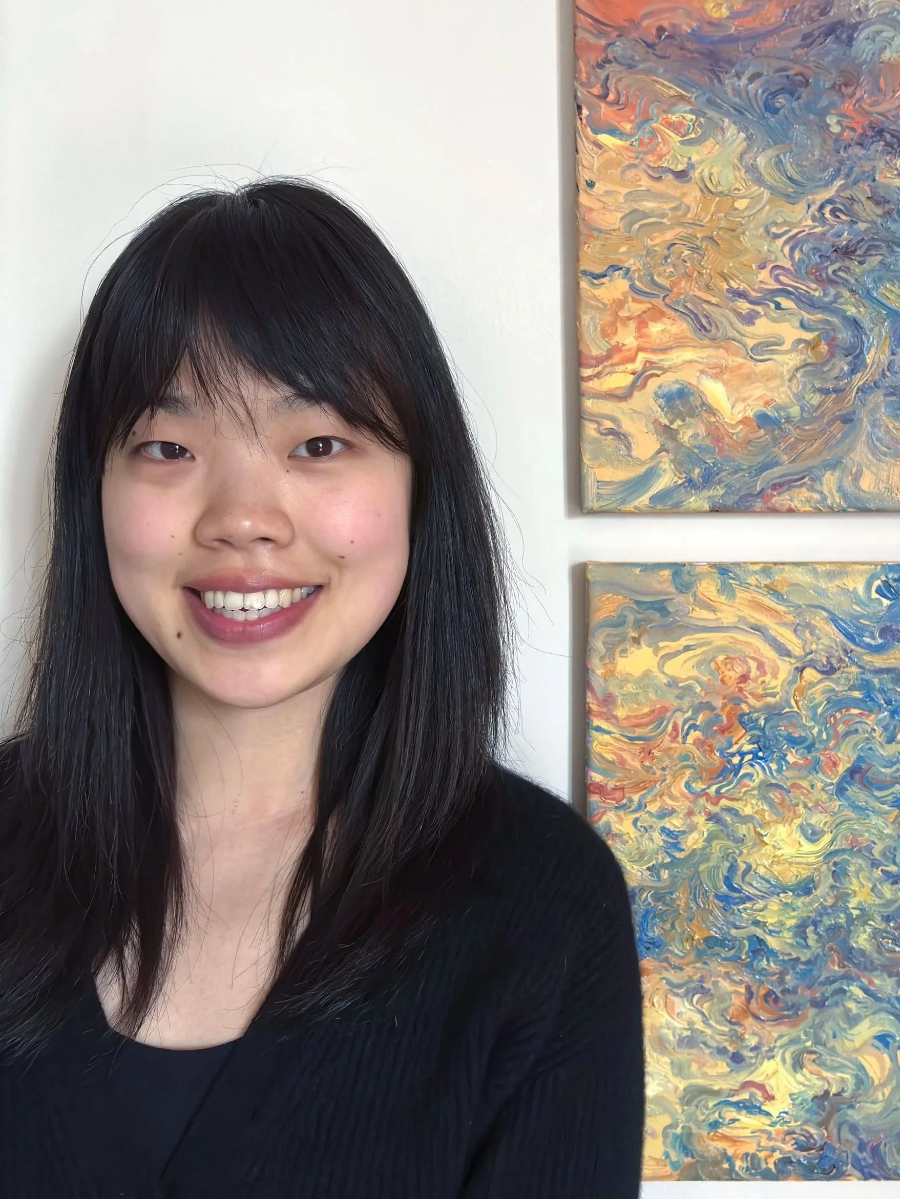 Portrait of contemporary abstract artist Alyssa Zhang with a vibrant painting in the background