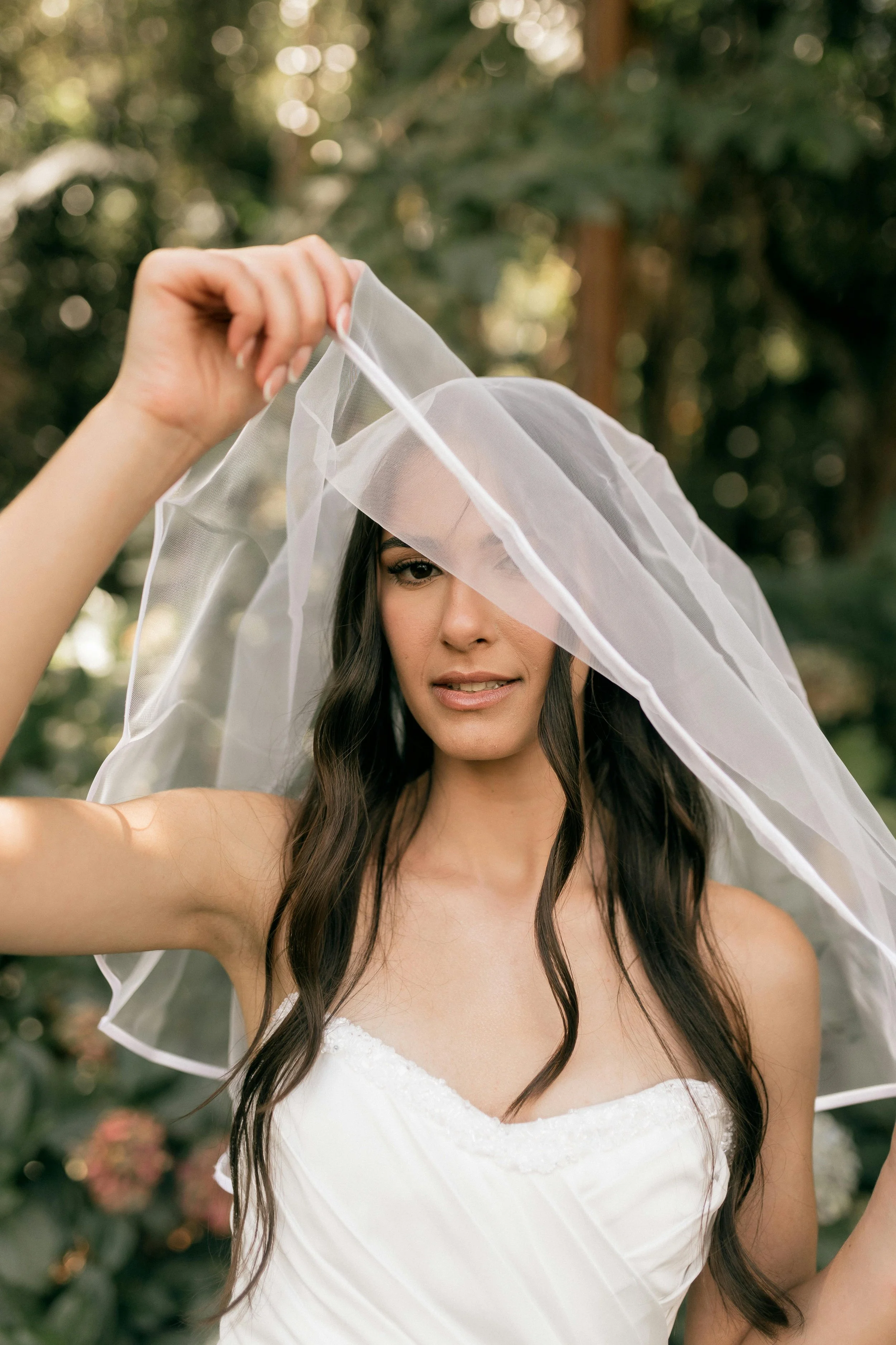 Bride wearing a strapless wedding dress and a long tulle veil