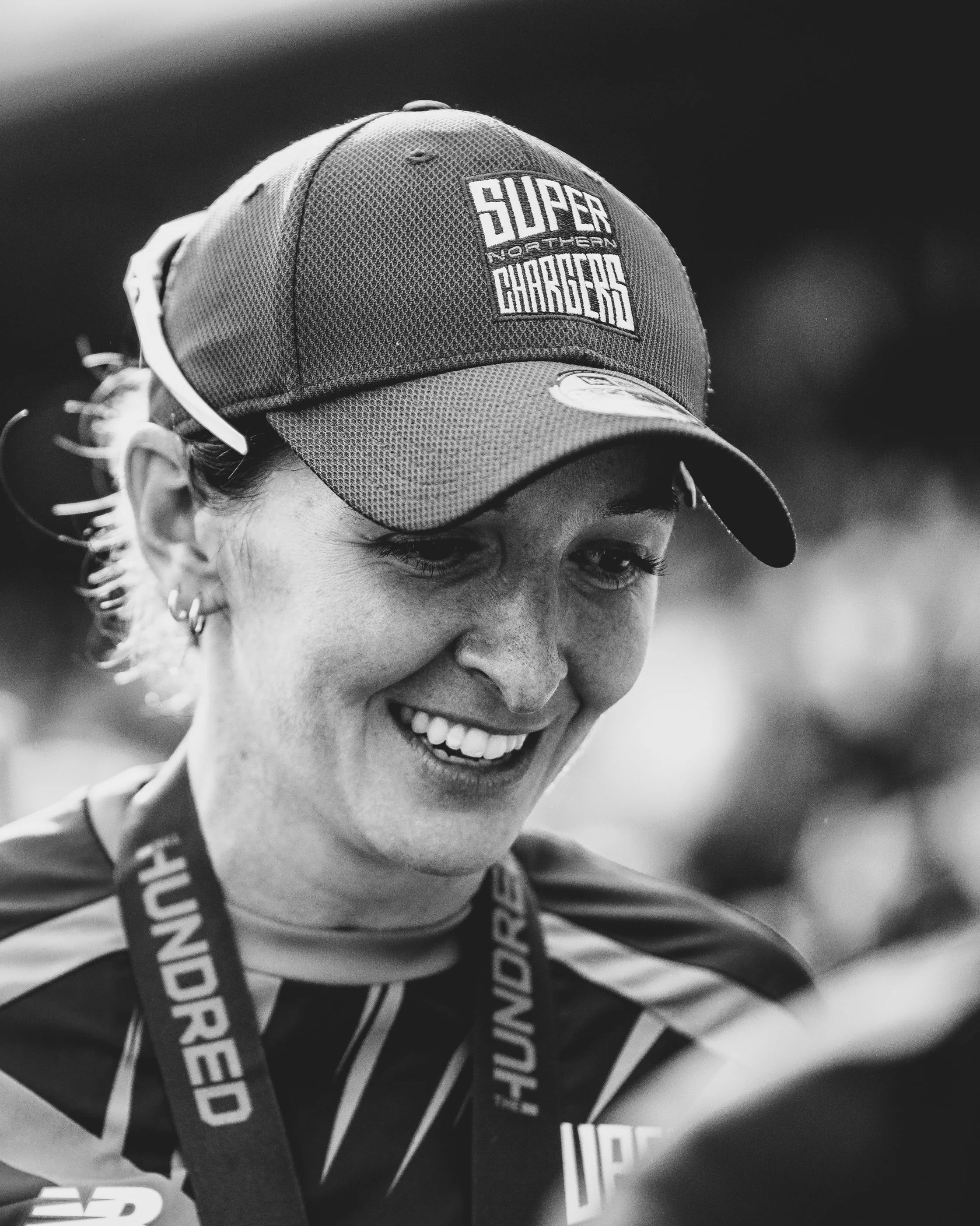 Close-up of a person wearing a cap with a patch that reads 'Super Northern Chargers' and a lanyard with the text 'ENDURANCE'.