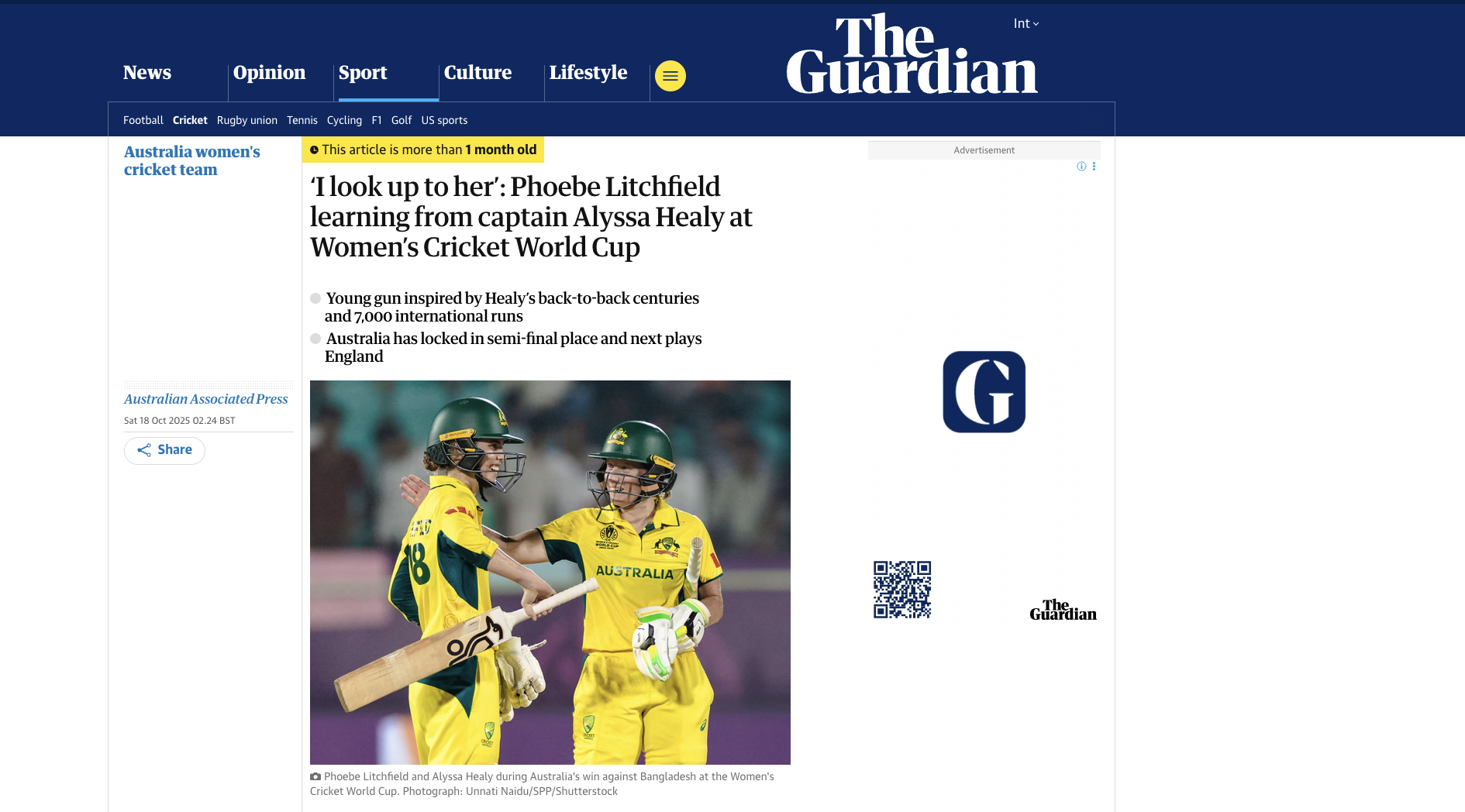 Two female cricket players in yellow uniforms with green helmets celebrating on a cricket field during a match.