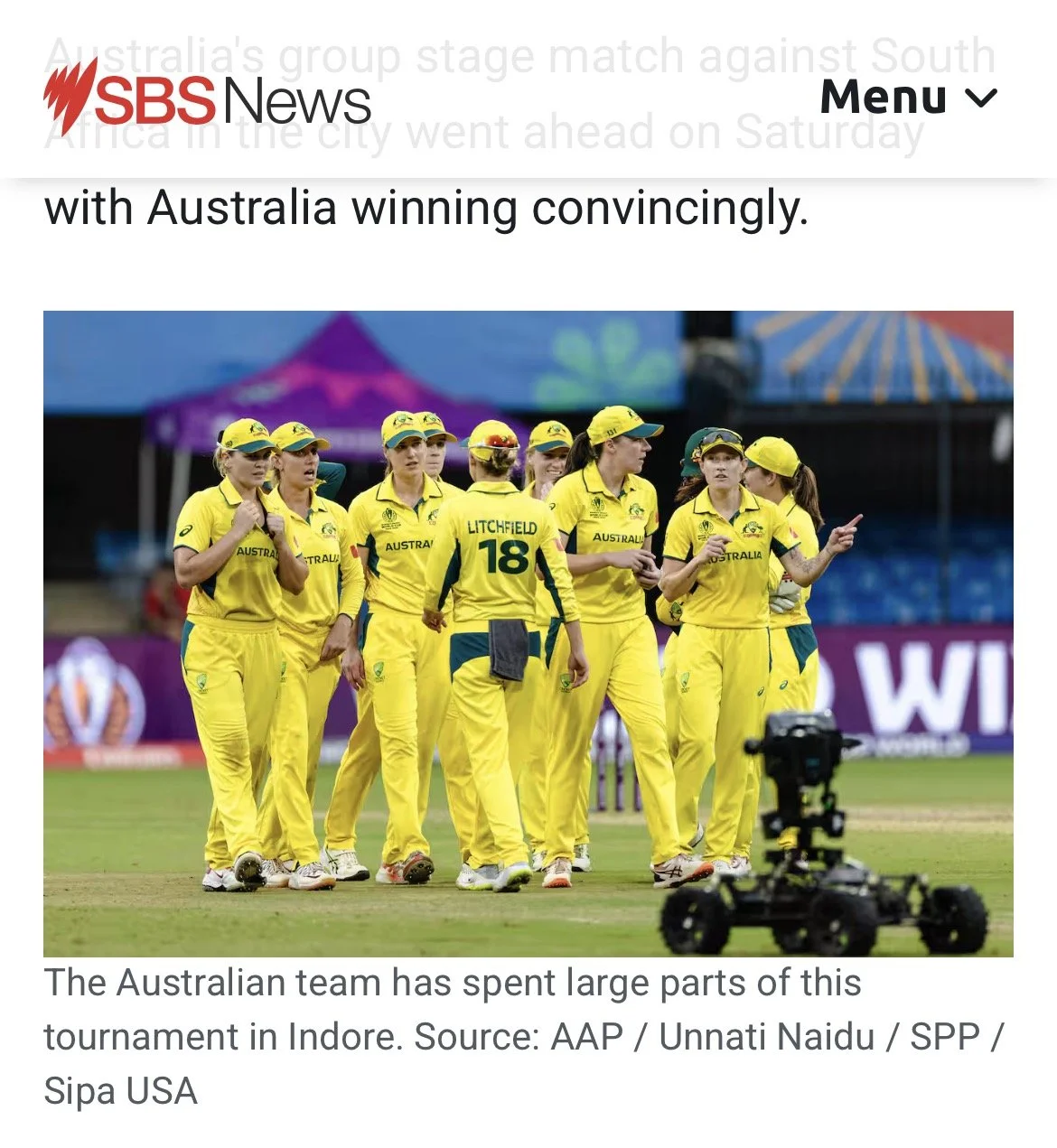 Australian women's cricket team in yellow uniforms on the field during a match at a stadium.