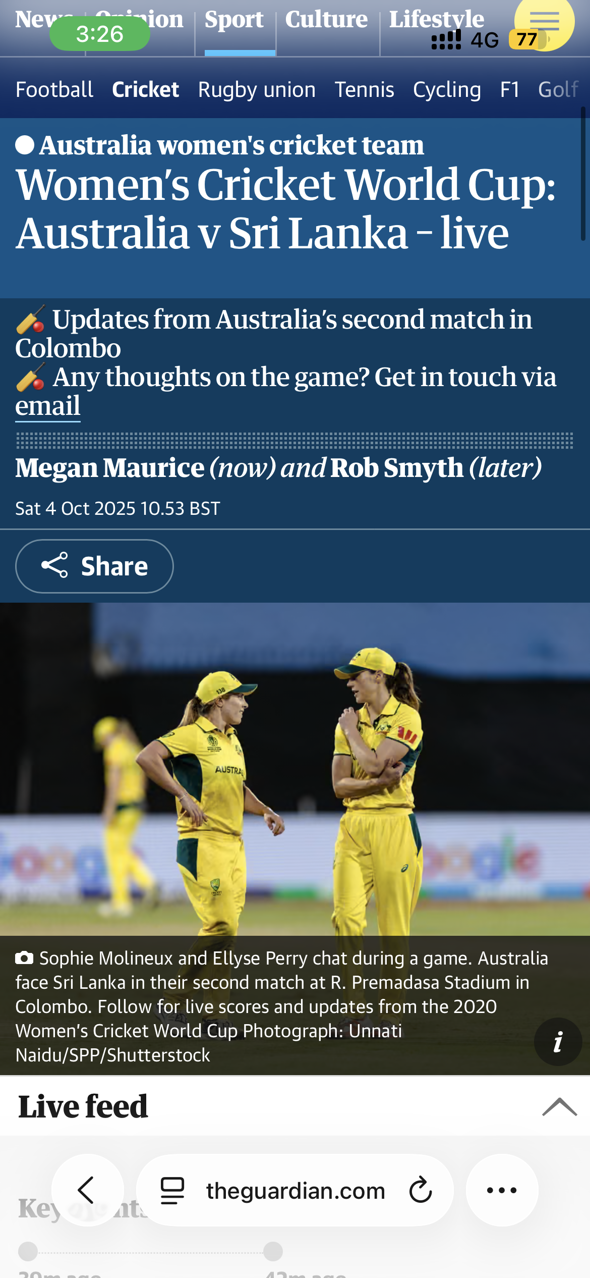 Two female Australian cricket players in yellow uniforms and hats, engaged in a conversation on the cricket field during a match against Sri Lanka at R. Premadasa Stadium in Colombo.