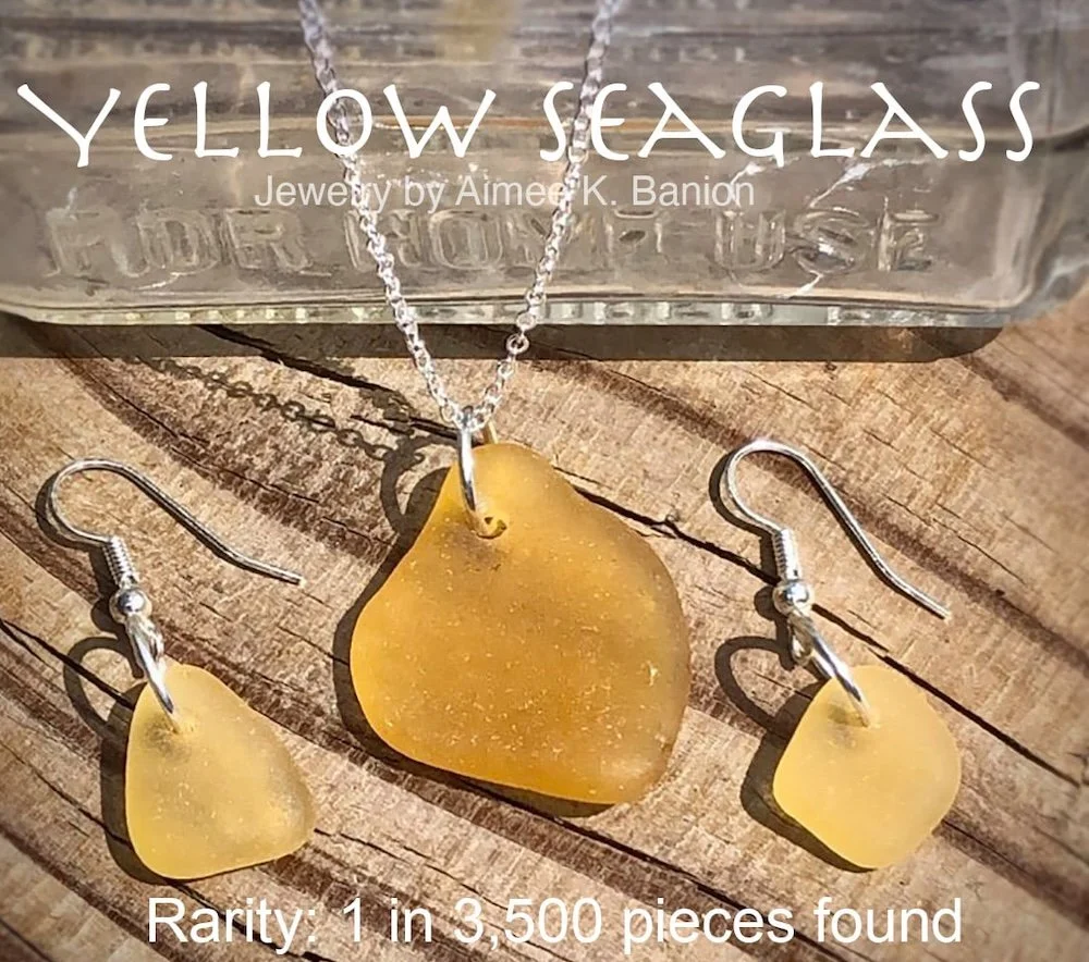 A jewelry set featuring yellow sea glass earrings and a necklace with a yellow sea glass pendant. The jewelry is displayed on a wooden surface, with a plastic container labeled "YELLOW SEAGLASS" in the background. The set is rare, with only one in 3,