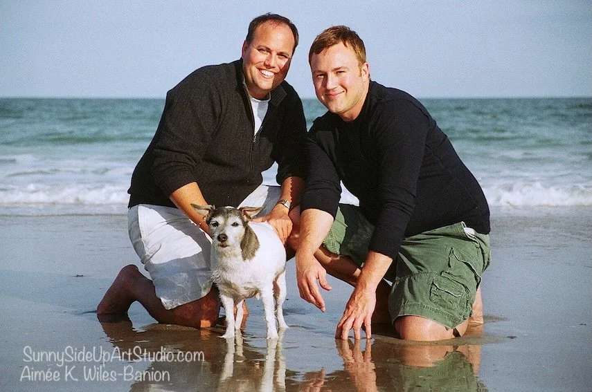 Two men at St. Augustine Beach Florida with their dog, a portrait taken by Aimee Wiles Banion of SunnySideUpArtStudio.com
