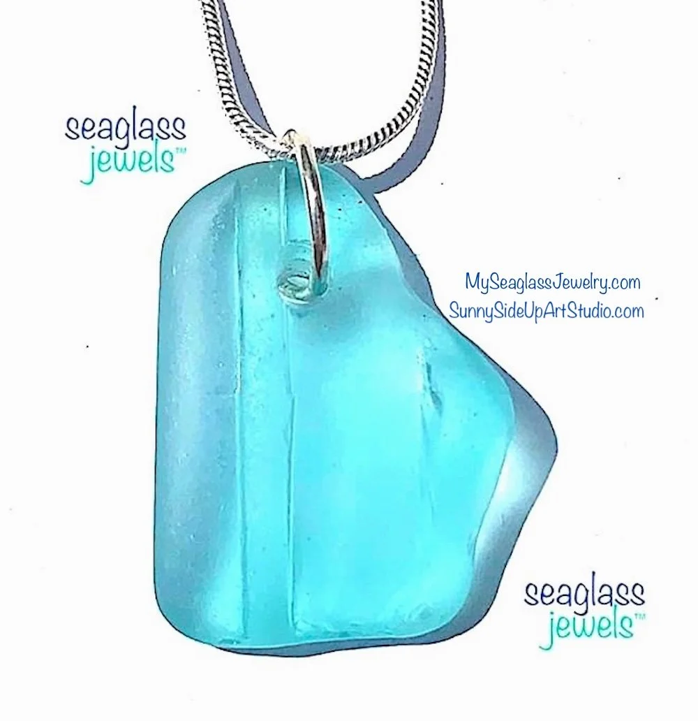 A rare turquoise sea glass pendant necklace with a silver jump ring attached to a silver chain. The background is white with text advertising 'Seaglass Jewels' and website links.