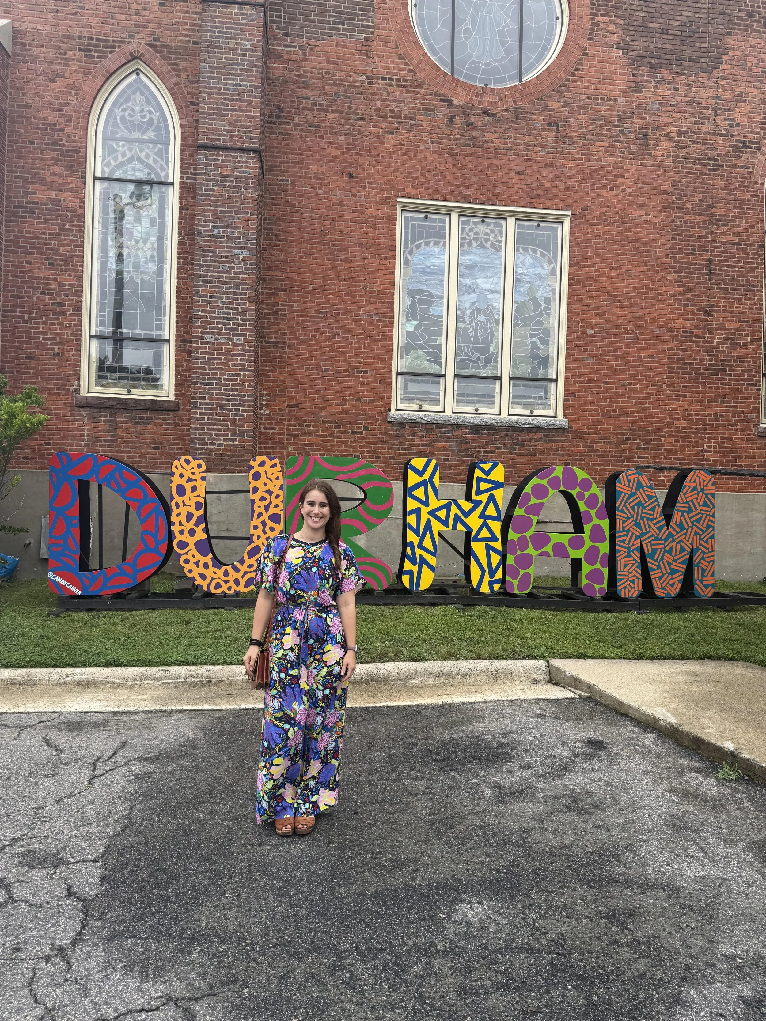 Anna Ruderman standing in front of a sign that says Durham