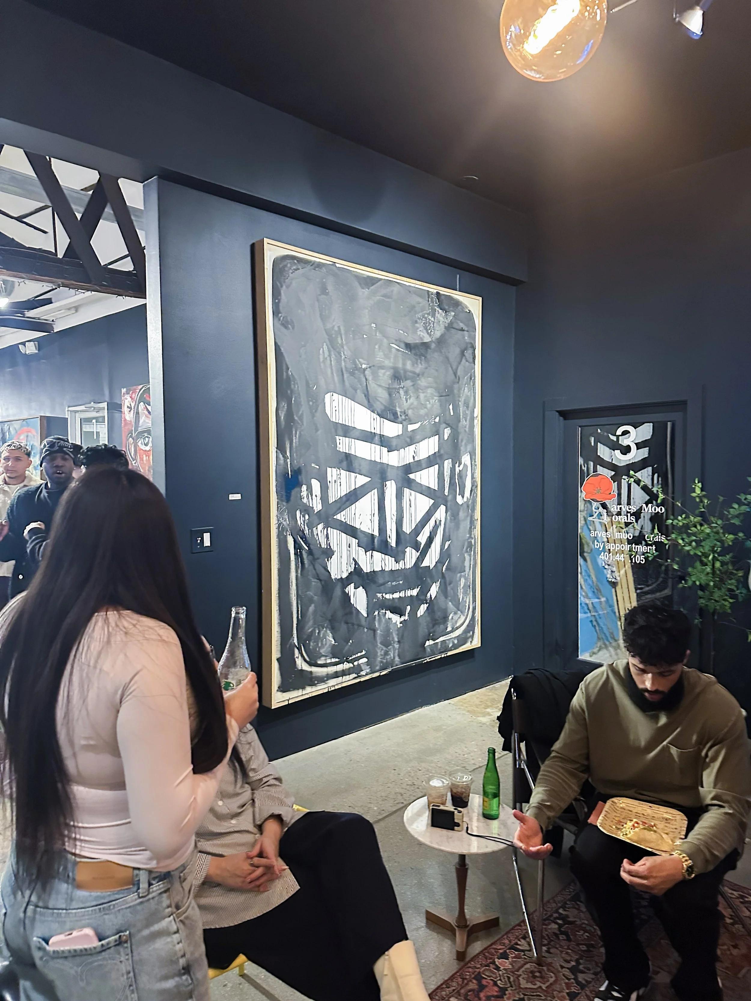 Still photo of artwork titled "Mr.Future 454" by artist Stephen Cook, displayed at OneWay Gallery in Narragansett, RI on 3.8.26. Image is portrayed during a private event within the gallery as guests are exploring the artworks and socializing. 