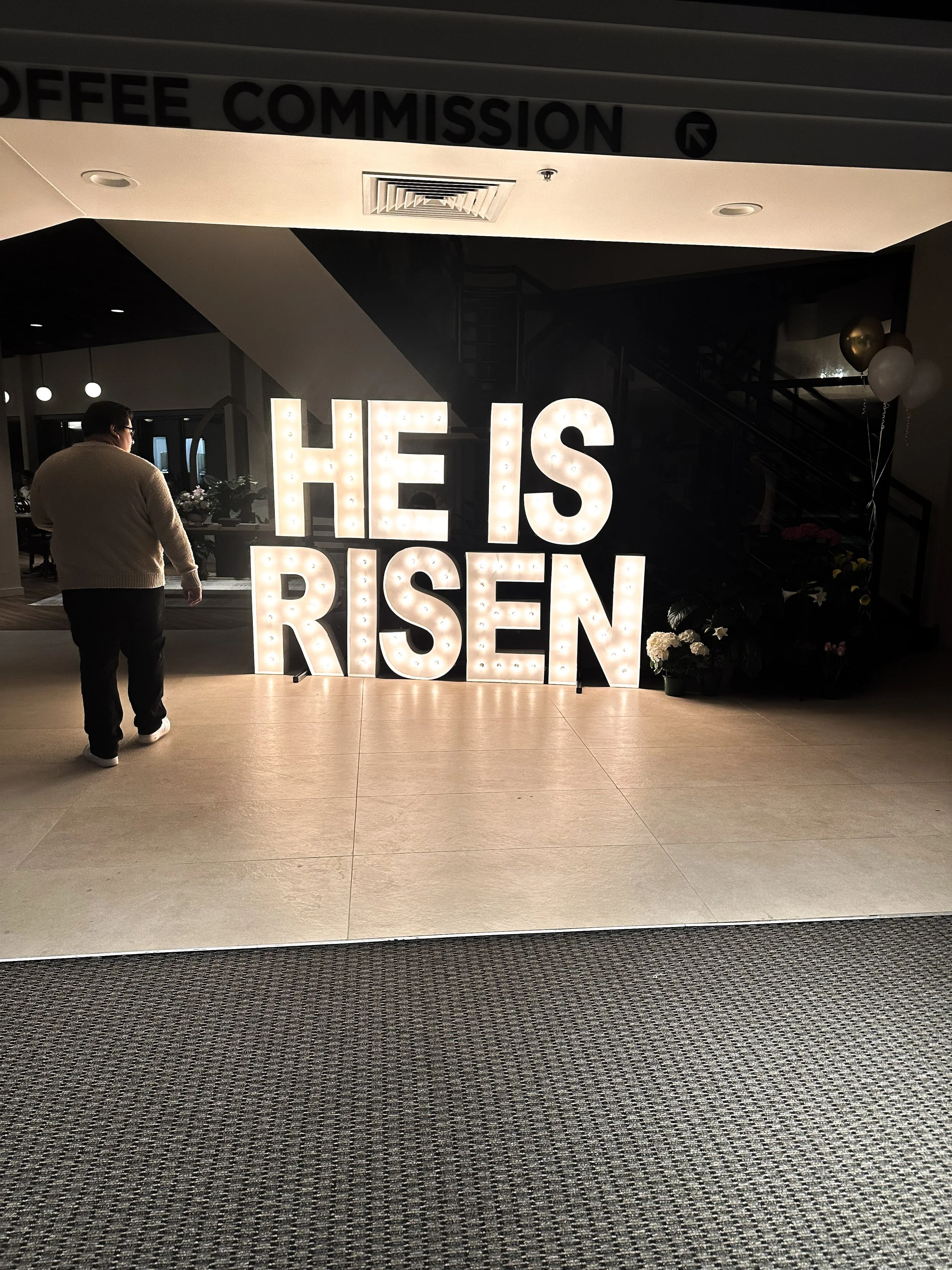 Taken 4.4.26 - Volunteer Kevin Rodriguez closes up the church after thousands of people have left, illuminated by a "He is Risen" sign, denoting Jesus Christ's resurrection. 