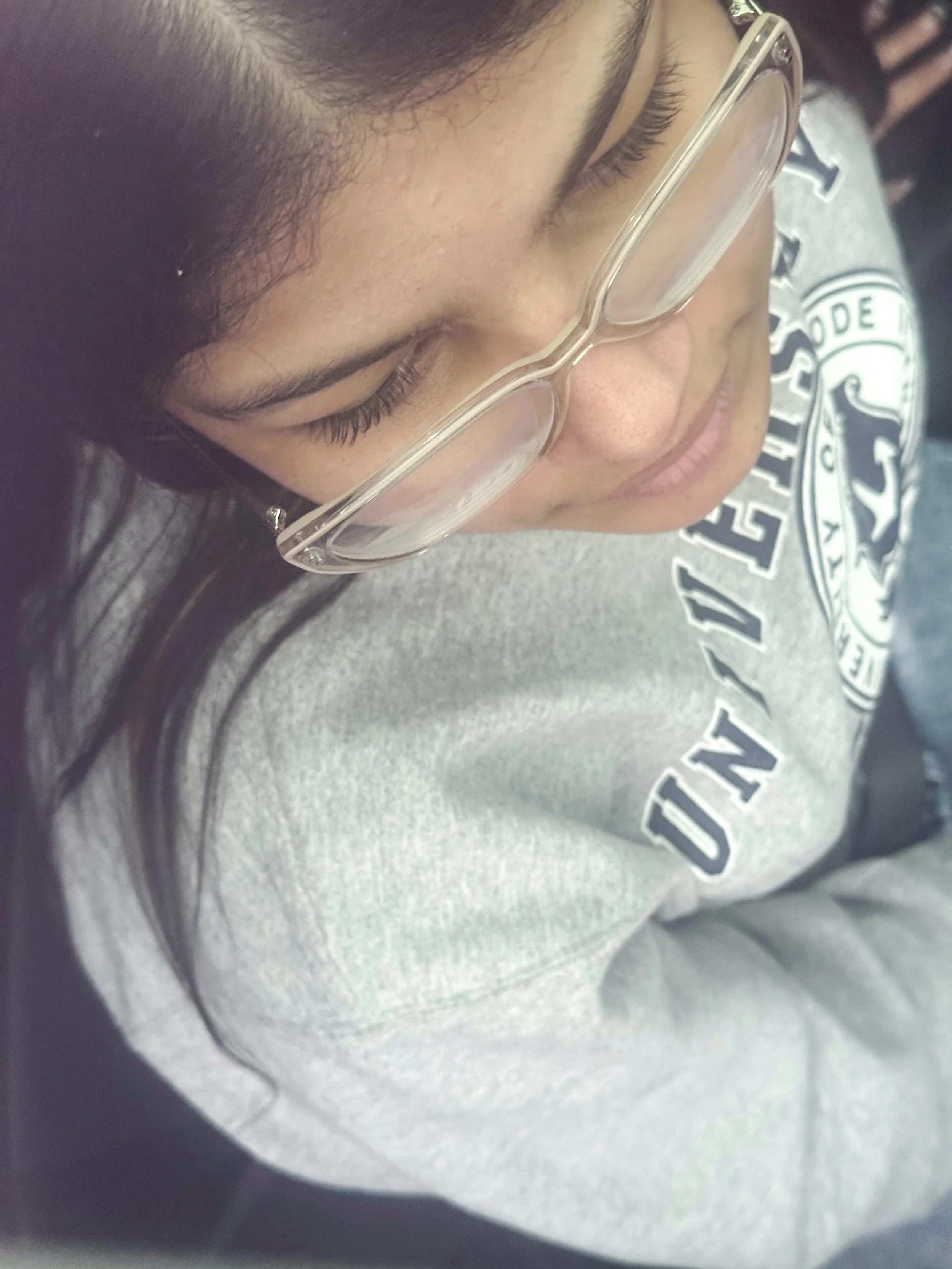 Photo of Analy Vega on 2.22.26 as she is looking out the car window. Image captured through the sunroof capturing the soft light of a cloudy day. 