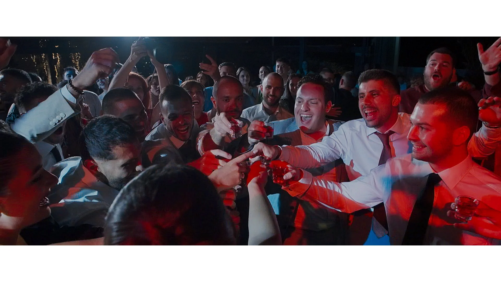 Group of people celebrating with drinks in a festive atmosphere at a party or event.